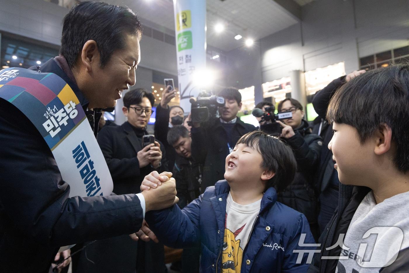 본문 이미지 - 정청래 더불어민주당 대표가 13일 서울 용산역에서 설 귀성객 인사를 하며 아이와 손을 잡고 있다. 2026.2.13 ⓒ 뉴스1 이승배 기자