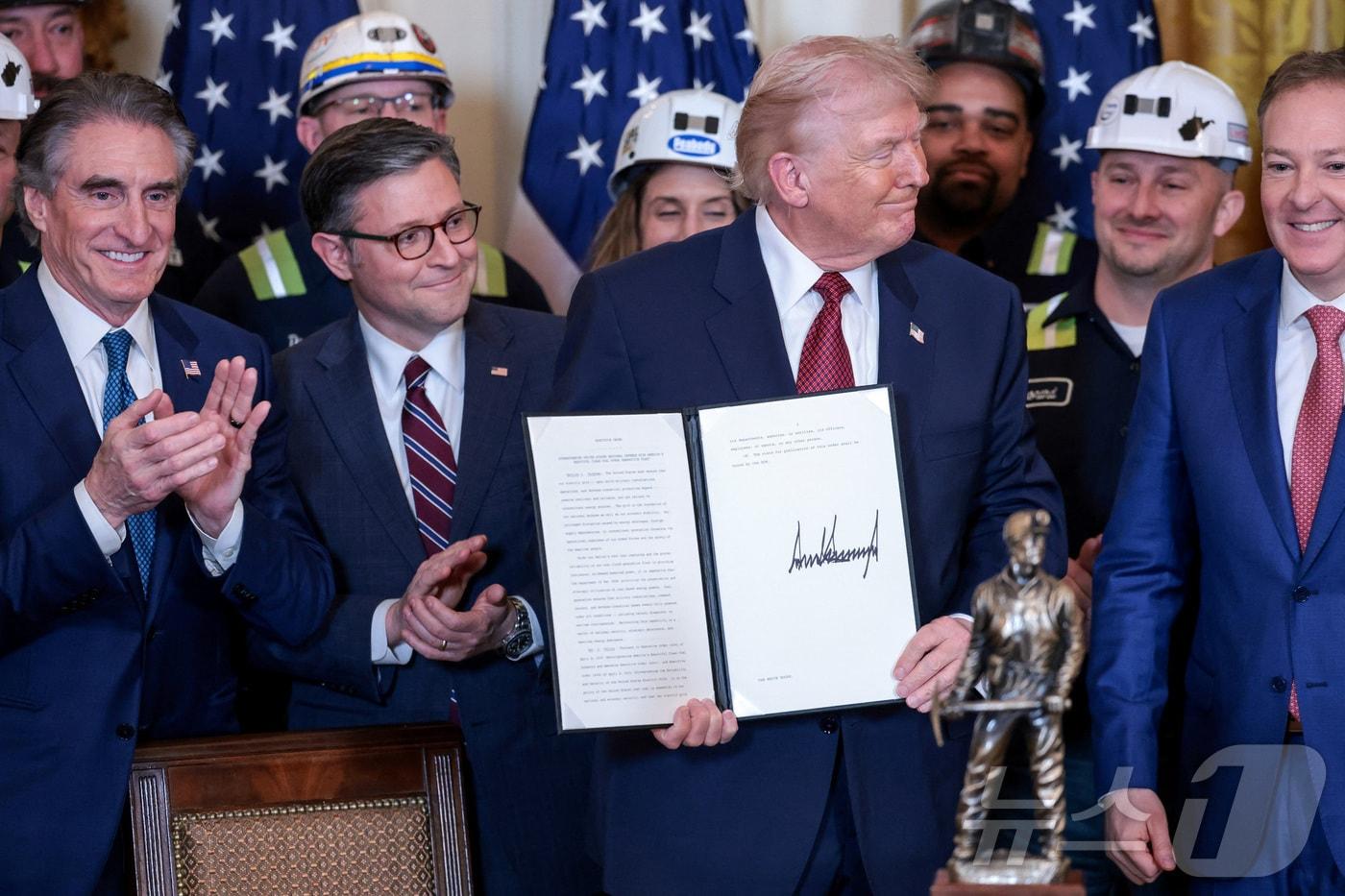 본문 이미지 - 11일(현지시간) 워싱턴DC 백악관 이스트룸에서 열린 석탄 에너지 홍보 행사 중 도널드 트럼프 미국 대통령의 책상 위에 '논란의 여지 없는 아름답고 깨끗한 석탄 챔피언'이라고 적힌 트로피가 놓여 있다. ⓒ 로이터=뉴스1