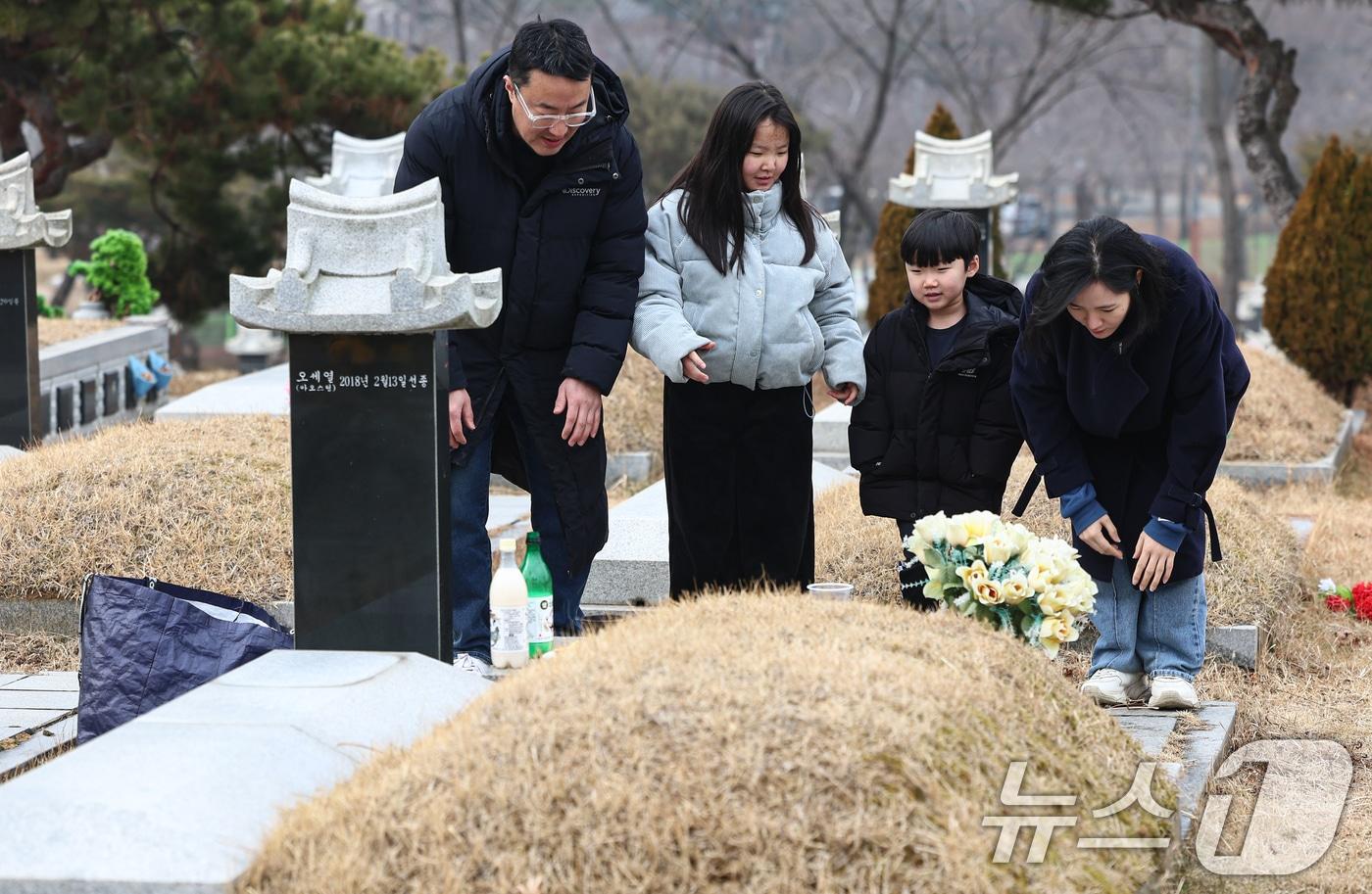 본문 이미지 - 설날을 닷새 앞둔 12일 인천 부평구 인천가족공원을 찾은 한 가족이 성묘하고 있다. 2026.2.13 ⓒ 뉴스1 김도우 기자