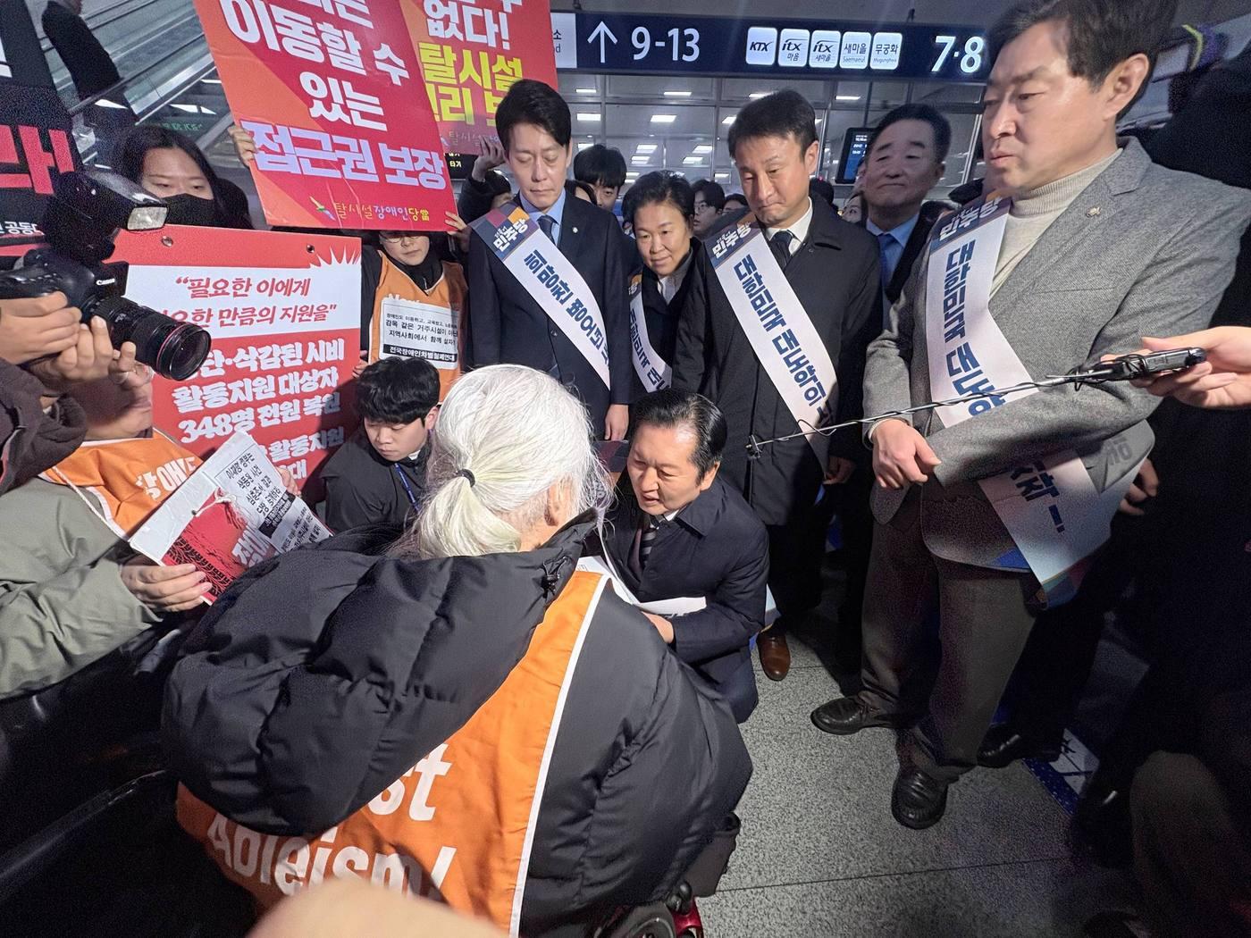 본문 이미지 - 박경석 전국장애인차별철폐연대 대표가 서울 용산역에서 정청래 더불어민주당 대표에게 면담 요구안을 전달하는 모습.(전장연 제공)