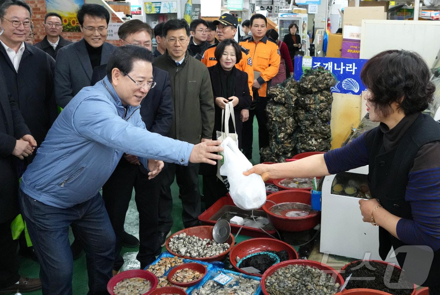 본문 이미지 - 김영록 전라남도지사가 설 명절을 앞둔 13일 지역 전통시장인 광양 중마시장을 방문, 물품을 구매하며 상인들을 격려하고 있다.(전남도 제공. 재판매 및 DB금지) 2026.2.13 ⓒ 뉴스1 