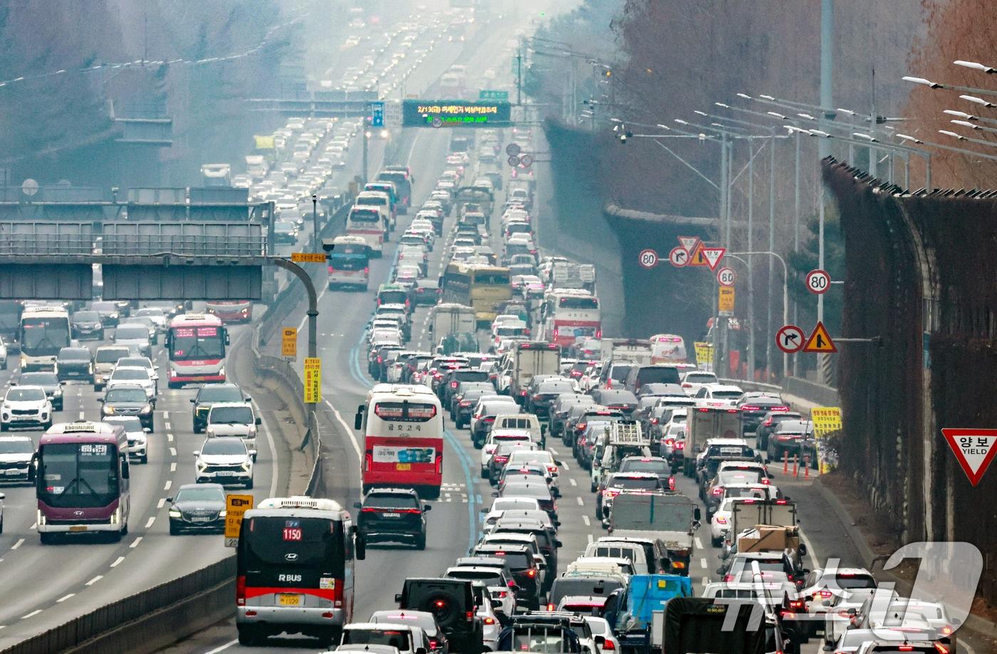 본문 이미지 - 설 연휴를 하루 앞둔 13일 서울 서초구 잠원IC 인근 경부고속도로 하행선이 정체를 빚고 있다. 한국도로공사에 따르면 이날 전국에서 554만 대가 고속도로를 이용하며 수도권에서 지방으로 47만 대, 지방에서 수도권으로 44만 대가 이동할 것이라 밝혔다. 2026.2.13 ⓒ 뉴스1 이호윤 기자