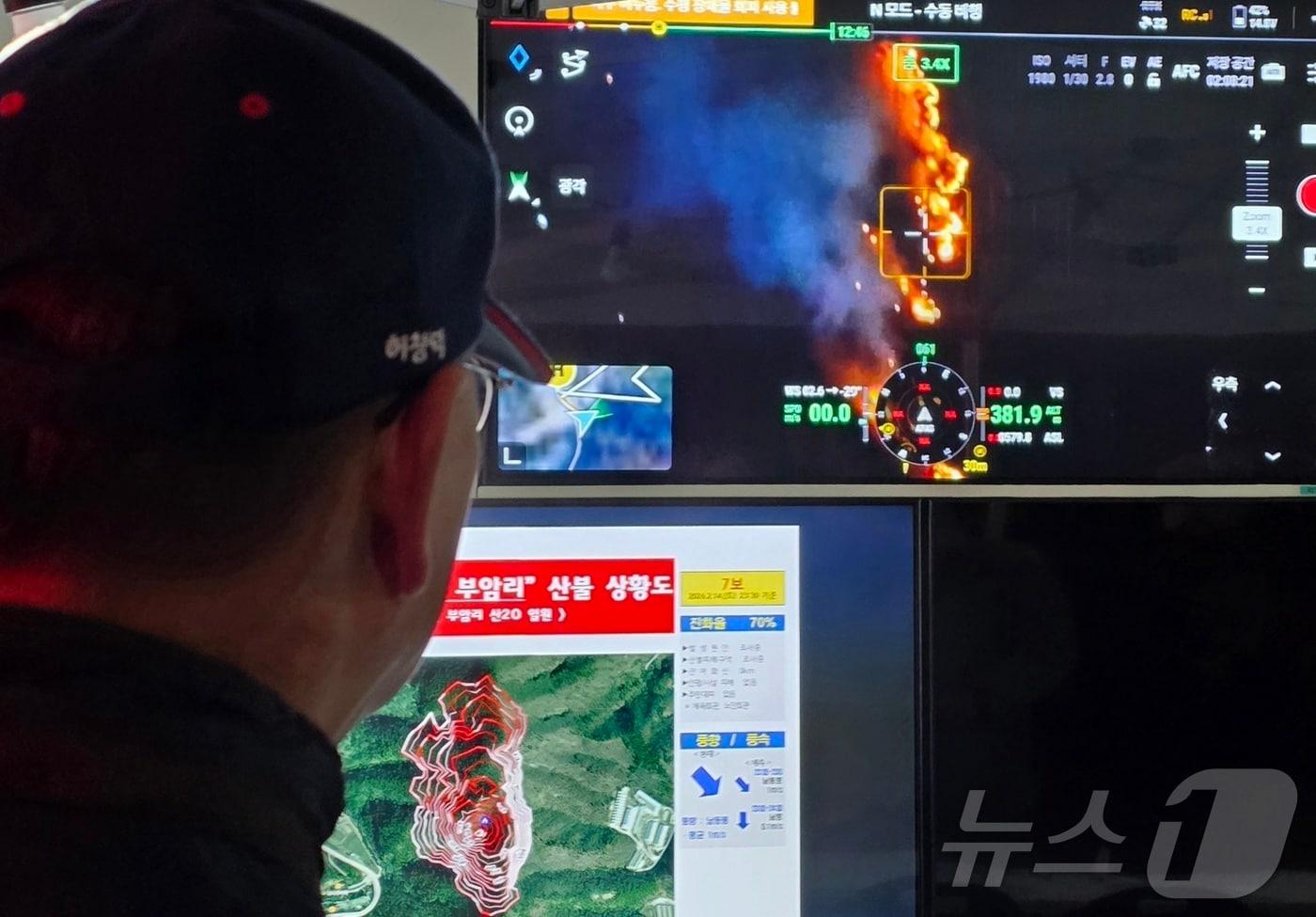 본문 이미지 - 14일 충남 금산군 진산면 백마산에서 발생한 산불 현장지휘소에서 산림청 관계자가 드론으로 촬영한 산불 현장 영상을 지켜보고 있다. 2026.2.15 ⓒ 뉴스1 이시우 기자