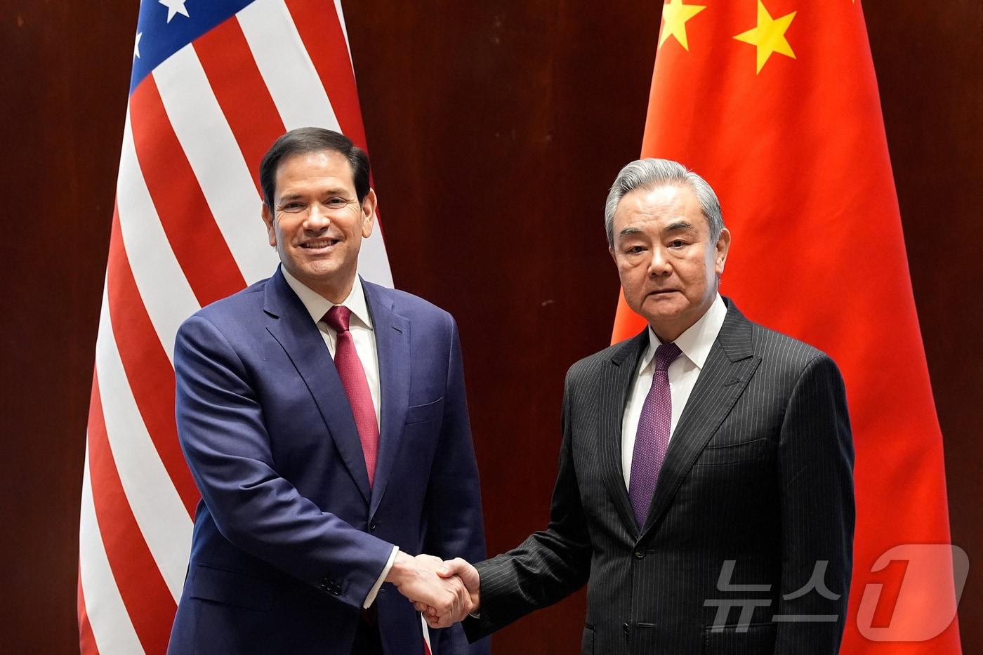 본문 이미지 - 마코 루비오 미국 국무장관과 왕이 중국 외교부장이 13일(현지시간) 독일 뮌헨안보회의(MSC)를 계기로 만나 악수하고 있다. 2026.02.14. ⓒ 로이터=뉴스1