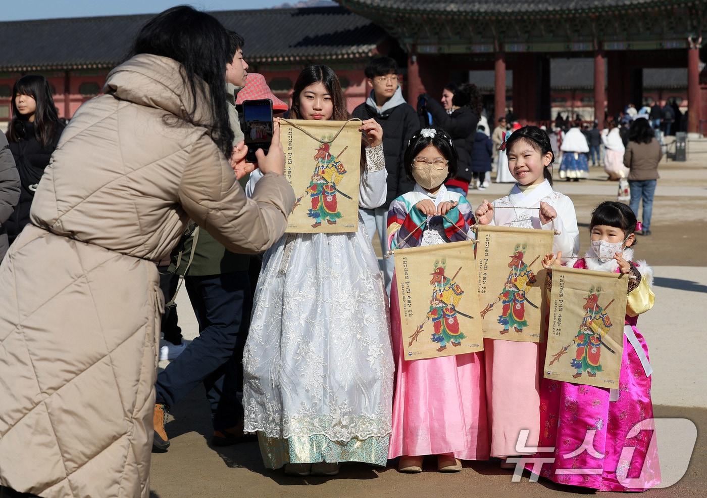 본문 이미지 - 설 연휴 첫날인 16일 서울 경복궁 흥례문 광장에서 열린 ‘2026년 병오년 설맞이 세화 나눔’ 행사에서 한복 입은 어린이들이 세화를 받은 뒤 기념 촬영을 하고 있다. 2026.2.16 ⓒ 뉴스1 박지혜 기자