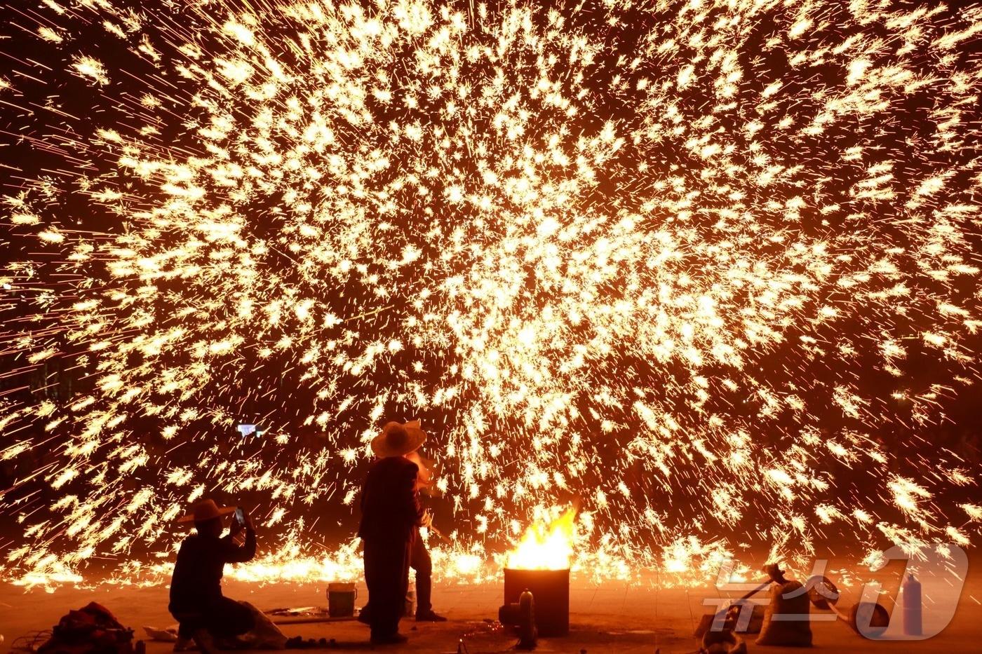 본문 이미지 - 14일(현지시간) 중국 허난성 안양에서 공연자들이 녹인 철을 이용한 불꽃놀이 쇼를 선보이고 있다. 2026.02.14. ⓒ 신화=뉴스1