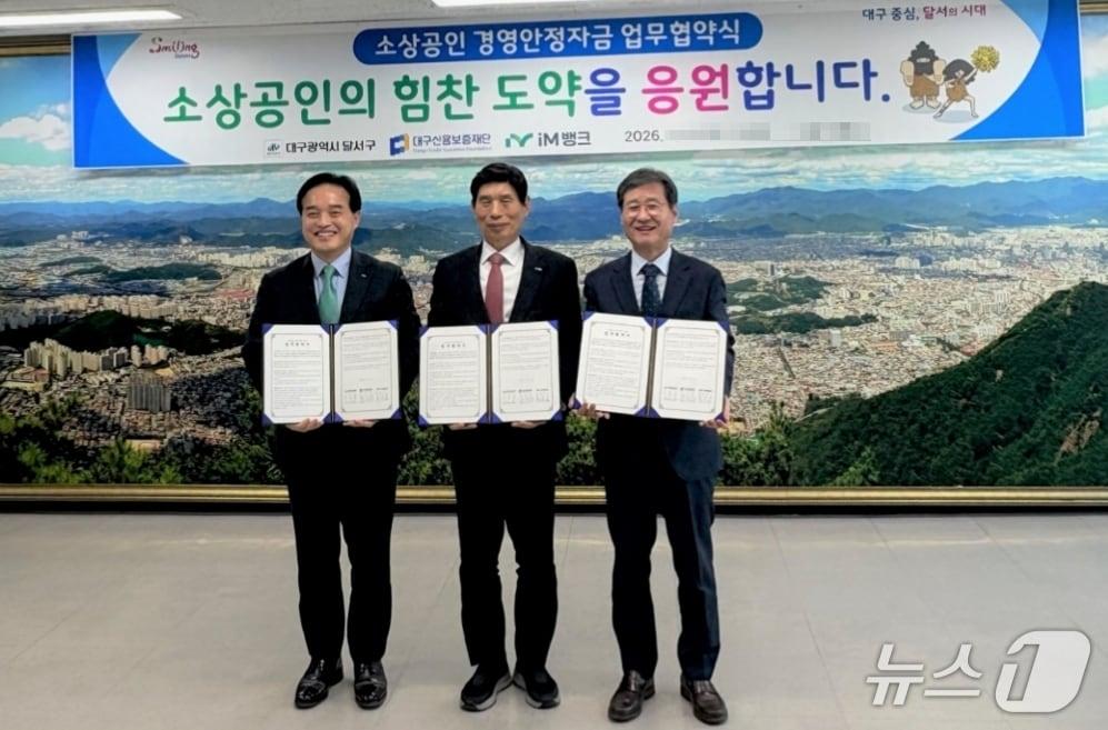본문 이미지 - 박진우 대구신용보증재단 이사장(오른쪽)과 이태훈 달서구청장(가운데), 최상수 iM뱅크 기관영업그룹 부행장이 소상공인 경영안정자금 지원을 위한 업무협약을 체결한 뒤 협약서를 펼쳐 보이고 있다.(대구신보 제공. 재판매 및 DB 금지)