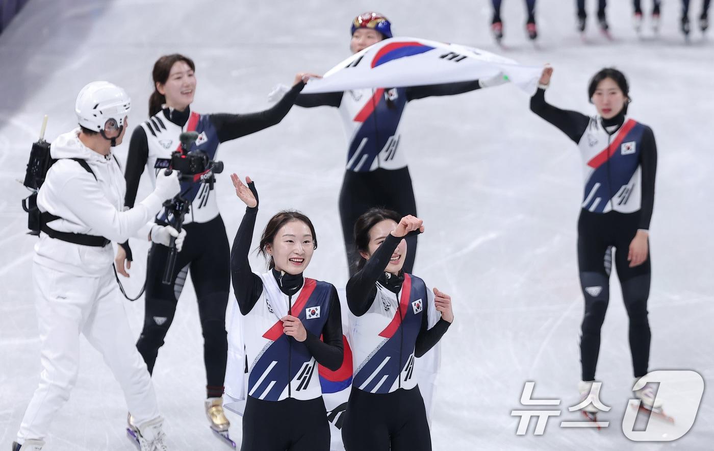 대한민국 여자 쇼트트랙 대표팀이 18일(현지시간) 이탈리아 밀라노 아이스스케이팅 아레나에서 열린 2026 밀라노·코르티나담페초 동계올림픽 쇼트트랙 여자 3000m 계주 결승에서 금메달을 차지한 후 태극기를 두르고 관중석을 향해 인사하고 있다. 2026.2.19 ⓒ 뉴스1 김성진 기자