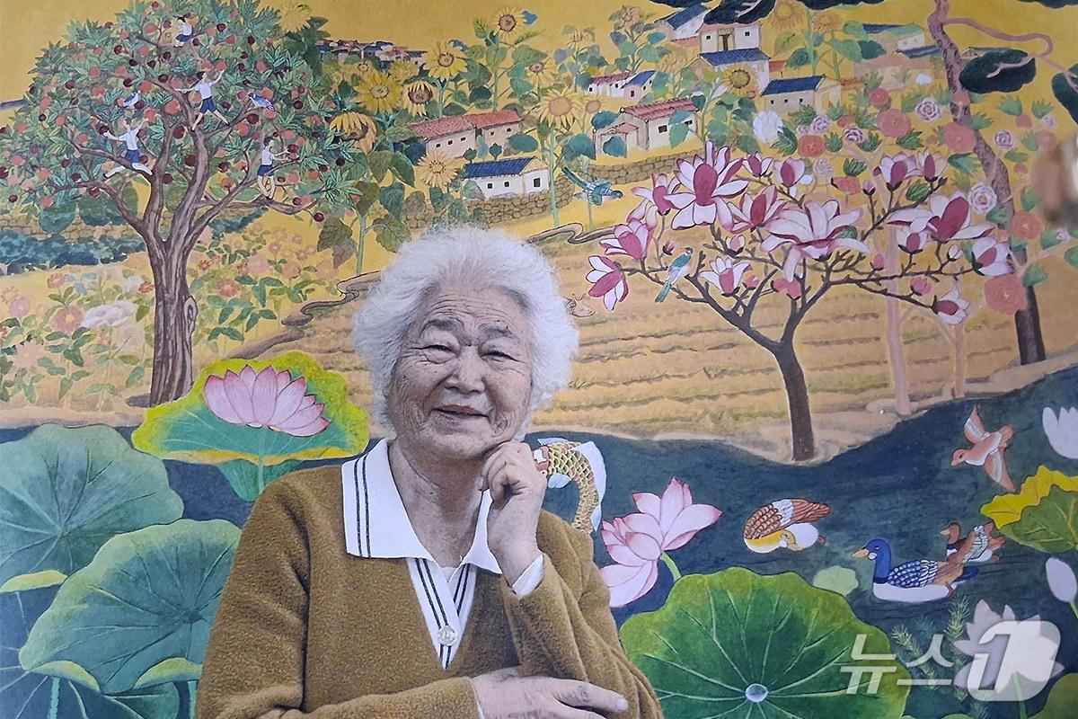 본문 이미지 - 이군자씨가 자신의 목원대 미술학부 한국화전공 졸업작품인 ‘추억은 아름다워’(162.2&times;130.3㎝, 장지에 채색, 2025) 앞에서 기념촬영을 하고 있다. (목원대 제공.재판매 및 DB금지)/뉴스1