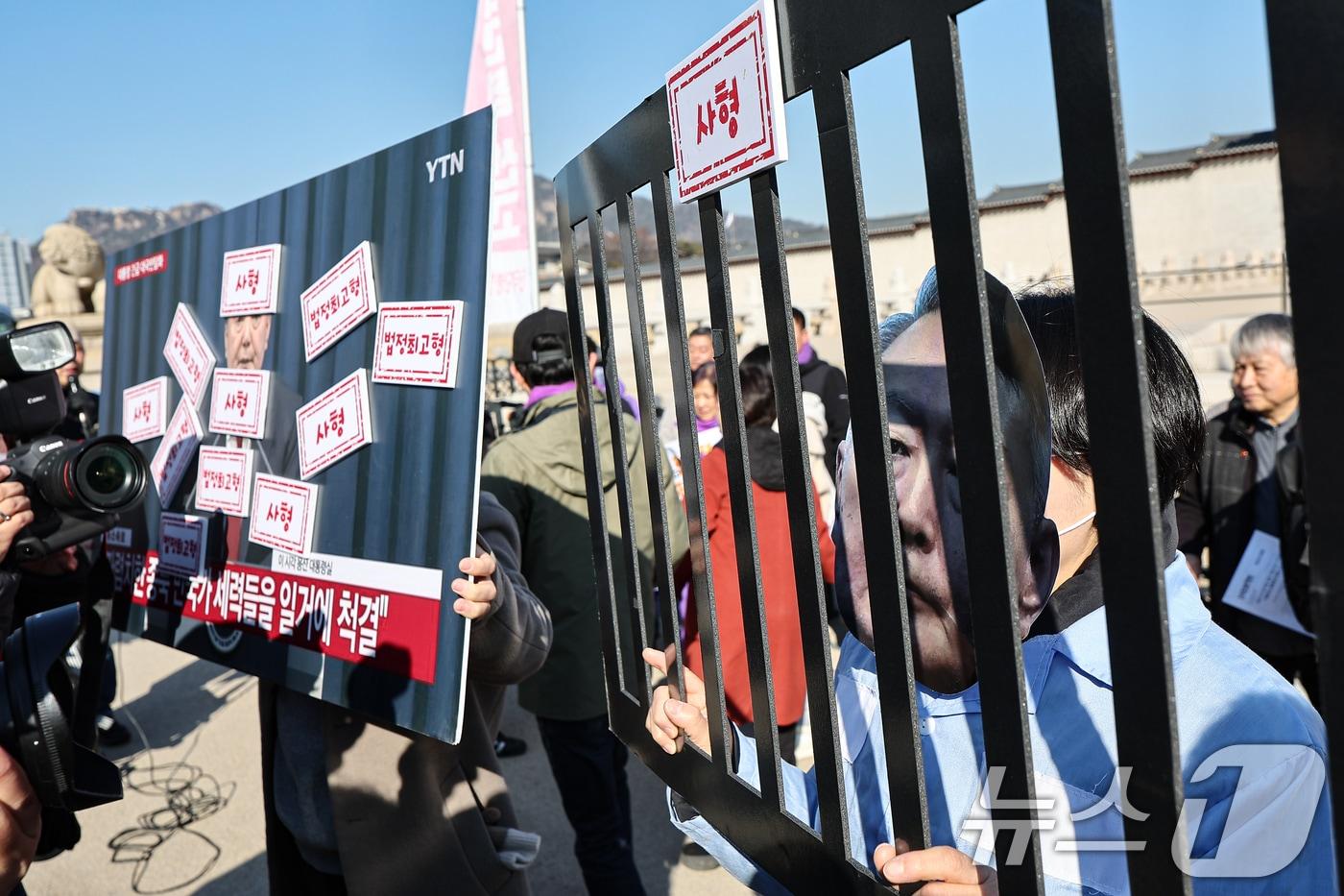 본문 이미지 - 전국민중행동 활동가들이 19일 서울 종로구 광화문 앞에서 윤석열 전 대통령 엄중 처벌 촉구 기자회견을 열고 퍼포먼스를 하고 있다. 2026.2.19 ⓒ 뉴스1 김도우 기자