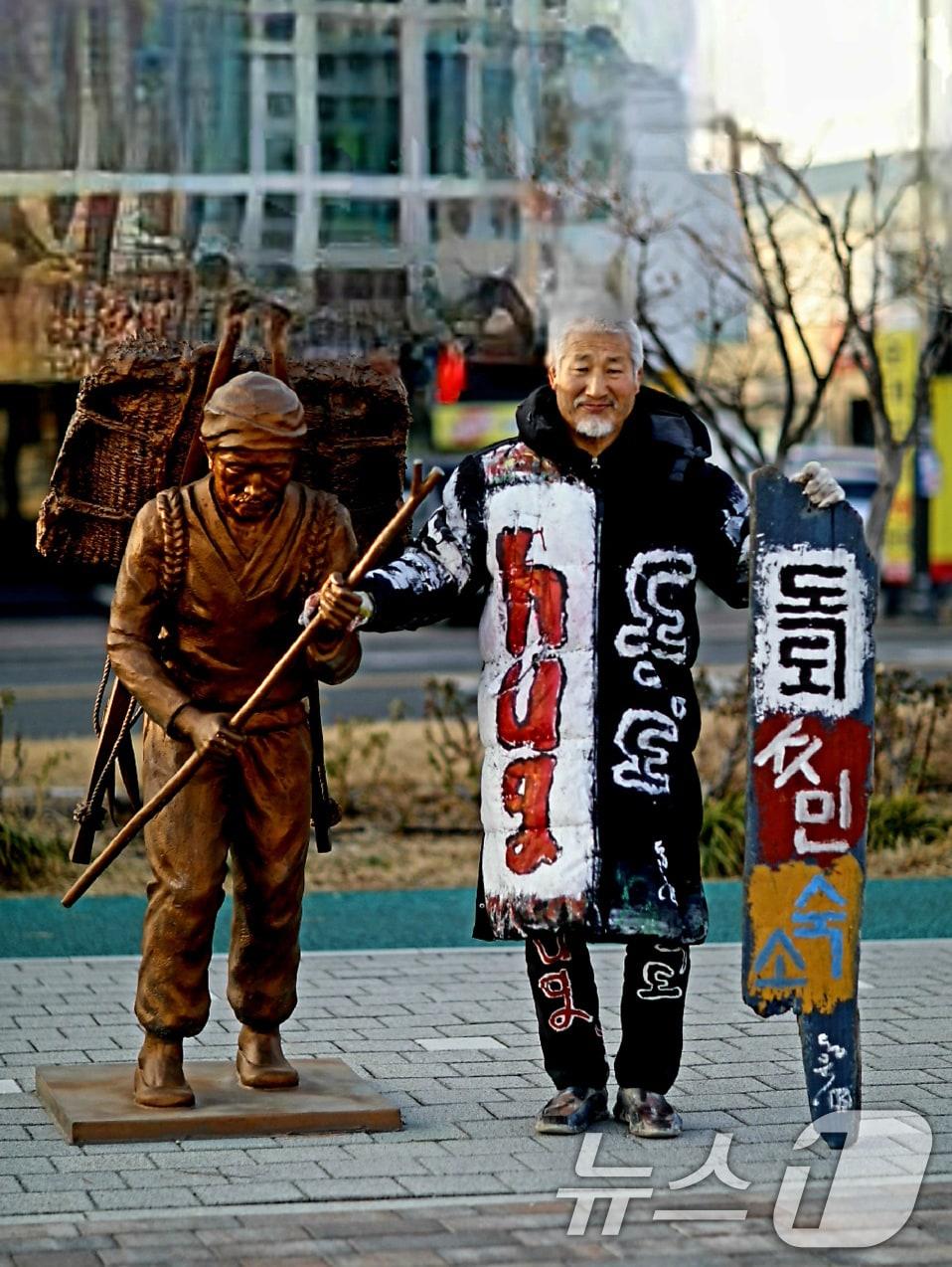 본문 이미지 - 독도서예가 김동욱씨가 19일 경북 포항시 북구 동빈항에서 日정부의 다케시마의 날(2월 22일)에 항의하는 독도 주민 현판식 퍼포먼스로 독도가 우리 땅임을 확인 시켜주고 있다. (서예가 김동욱씨제공, 재핀매 및 DB금지) 2026.2.19 ⓒ 뉴스1 최창호 기자