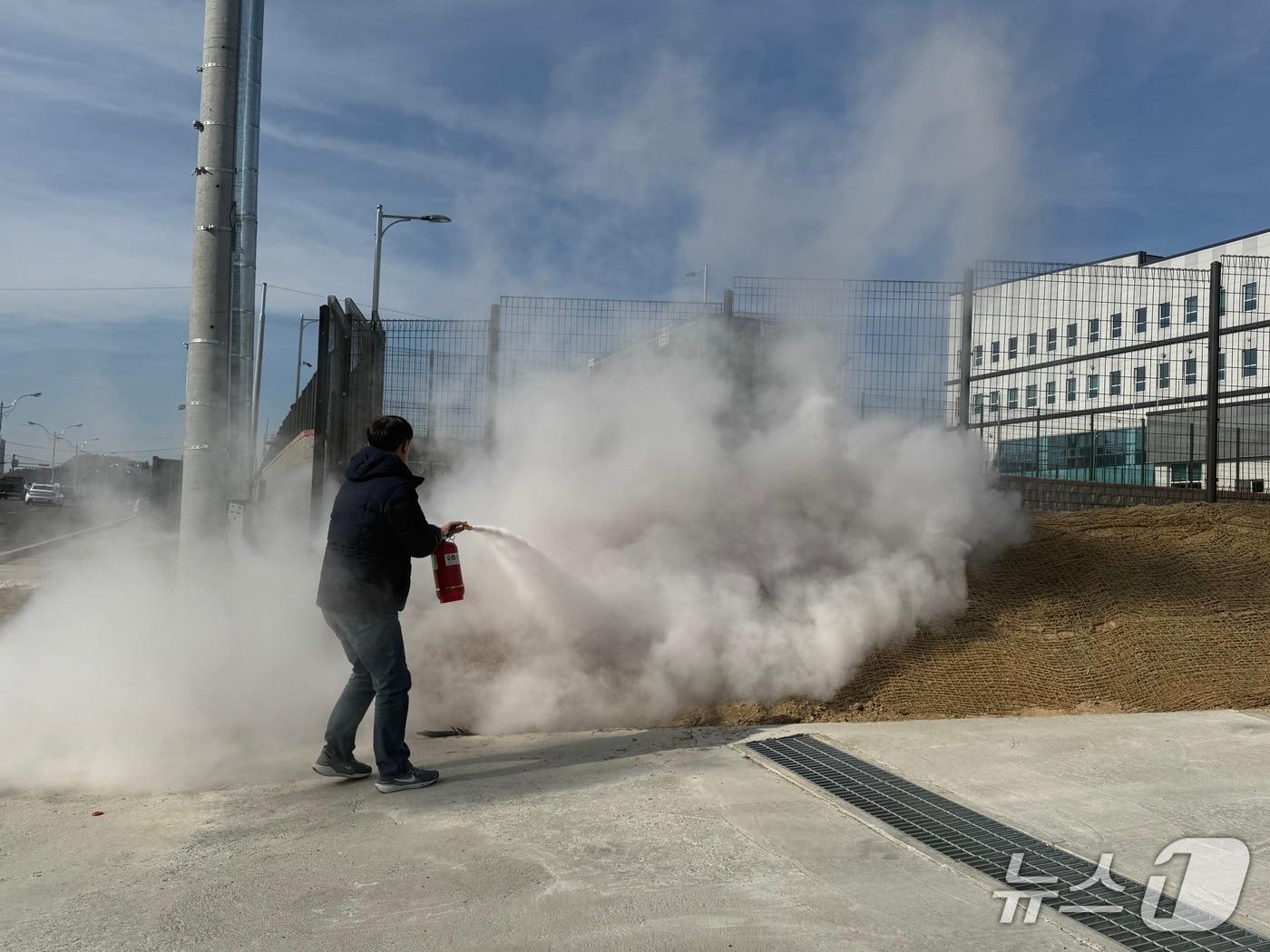 본문 이미지 - 보은소방서 소속 오승혁 소방위가 전신주 하단에서 발생한 불을  분말소화기로 초기 진화하고 있다. (옥천소방서 제공. 재판매 및 DB금지) /뉴스1