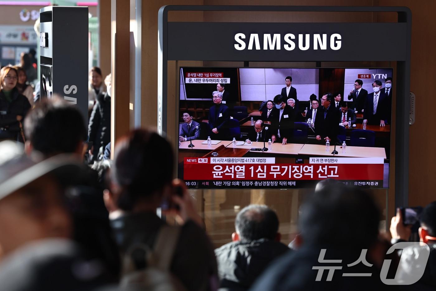본문 이미지 - 19일 오후 서울역 대합실에 설치된 TV를 통해 윤석열 전 대통령의 내란 우두머리 혐의 1심 선고가 생중계 되고 있다. 윤 전 대통령은 2024년 12월 3일 비상계엄을 선포한 지 443일 만에 무기징역을 선고받았다. 2026.2.19 ⓒ 뉴스1 구윤성 기자