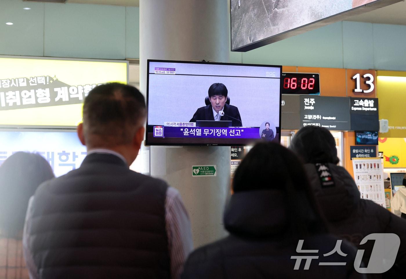 본문 이미지 - 19일 오후 광주 서구 광천동 유스퀘어복합터미널에서 시민들이 윤석열 전 대통령의 내란 우두머리 혐의 1심 무기징역 선고를 지켜보고 있다. 윤 전 대통령은 2024년 12월 3일 비상계엄을 선포한 지 443일 만에 무기징역을 선고받았다. 2026.2.19 ⓒ 뉴스1 박지현 기자