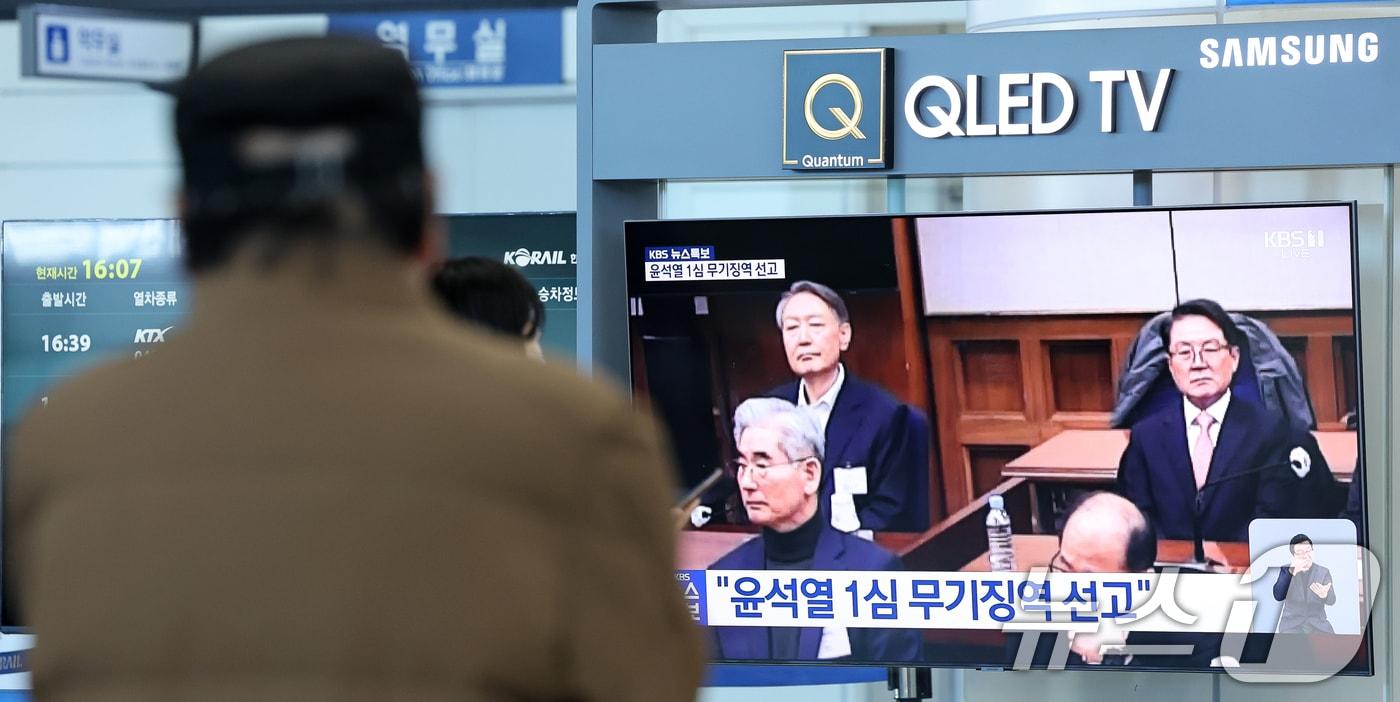 본문 이미지 - 19일 오후 대전역 대합실에서 시민들이 윤석열 전 대통령의 내란 우두머리 혐의 1심 선고 생중계를 시청하고 있다. 윤 전 대통령은 서울중앙지방법원에서 열린 1심에서 무기징역을 선고받았다. 2026.2.19 ⓒ 뉴스1 김기태 기자