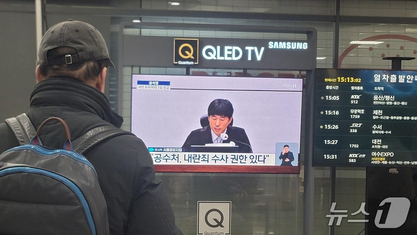 본문 이미지 - 19일 충북 청주 KTX오송역에서 한 시민이 TV 속 윤석열 전 대통령 재판 생중계를 지켜보고 있다.2026.2.19./뉴스1 임양규 기자