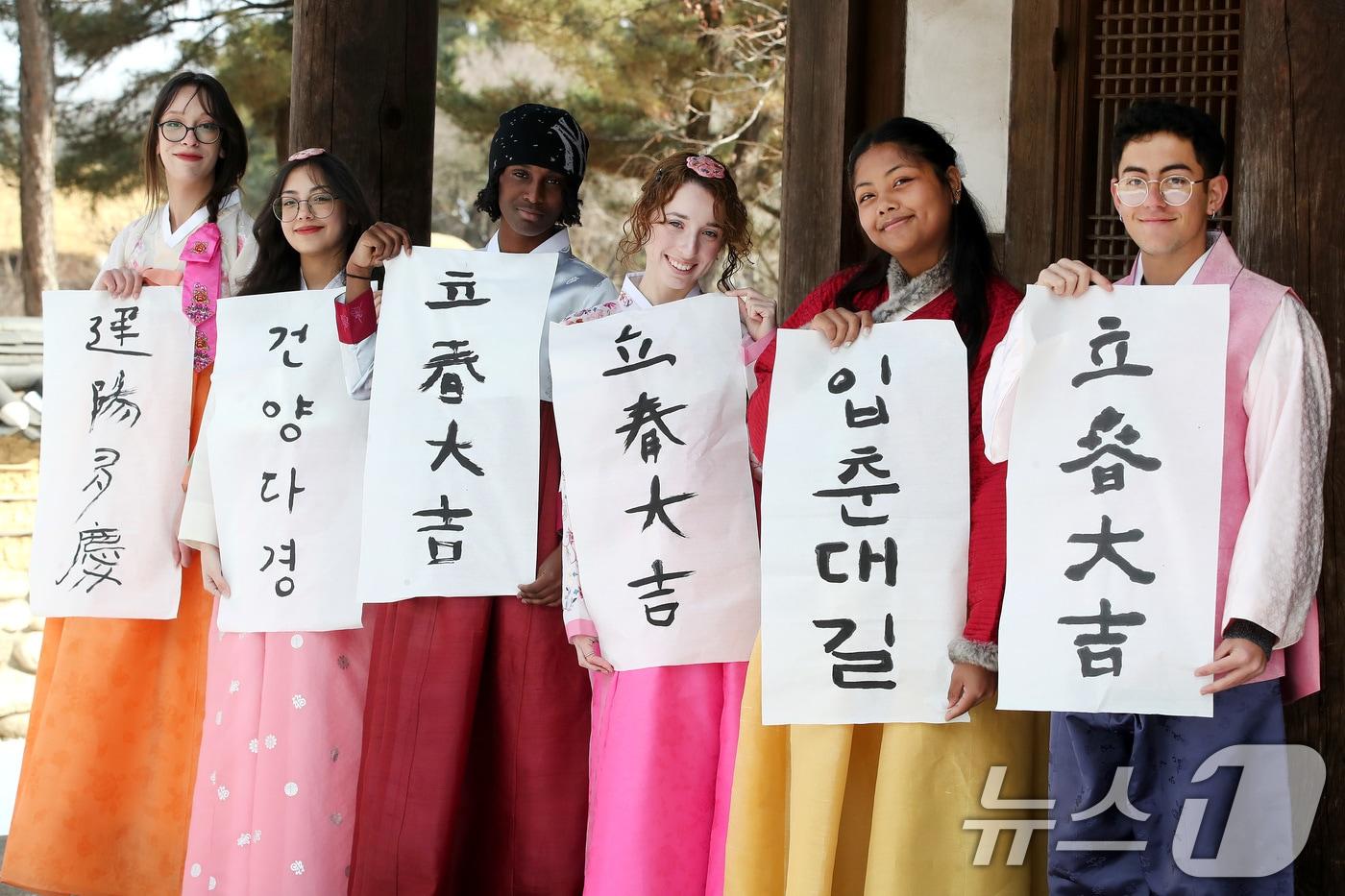 본문 이미지 - 봄의 시작을 알리는 절기 입춘(立春)을 이틀 앞두고 눈이 내린 2일 오전 경북 경산시 영남대 민속촌에서 한국 전통문화 체험에 참여한 외국인 유학생들이 붓글씨로 직접 쓴 입춘첩을 들어 보이고 있다. 2026.2.2/뉴스1 ⓒ News1 공정식 기자