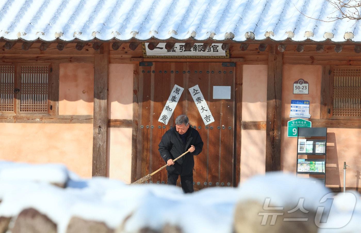 본문 이미지 - 지난 2일 경남 함양군 지곡면 개평한옥마을에서 한 관광해설사가 빗자루로 눈을 치우고 있다. (함양군 제공. 재판매 및 DB 금지) 2026.2.2 ⓒ 뉴스1