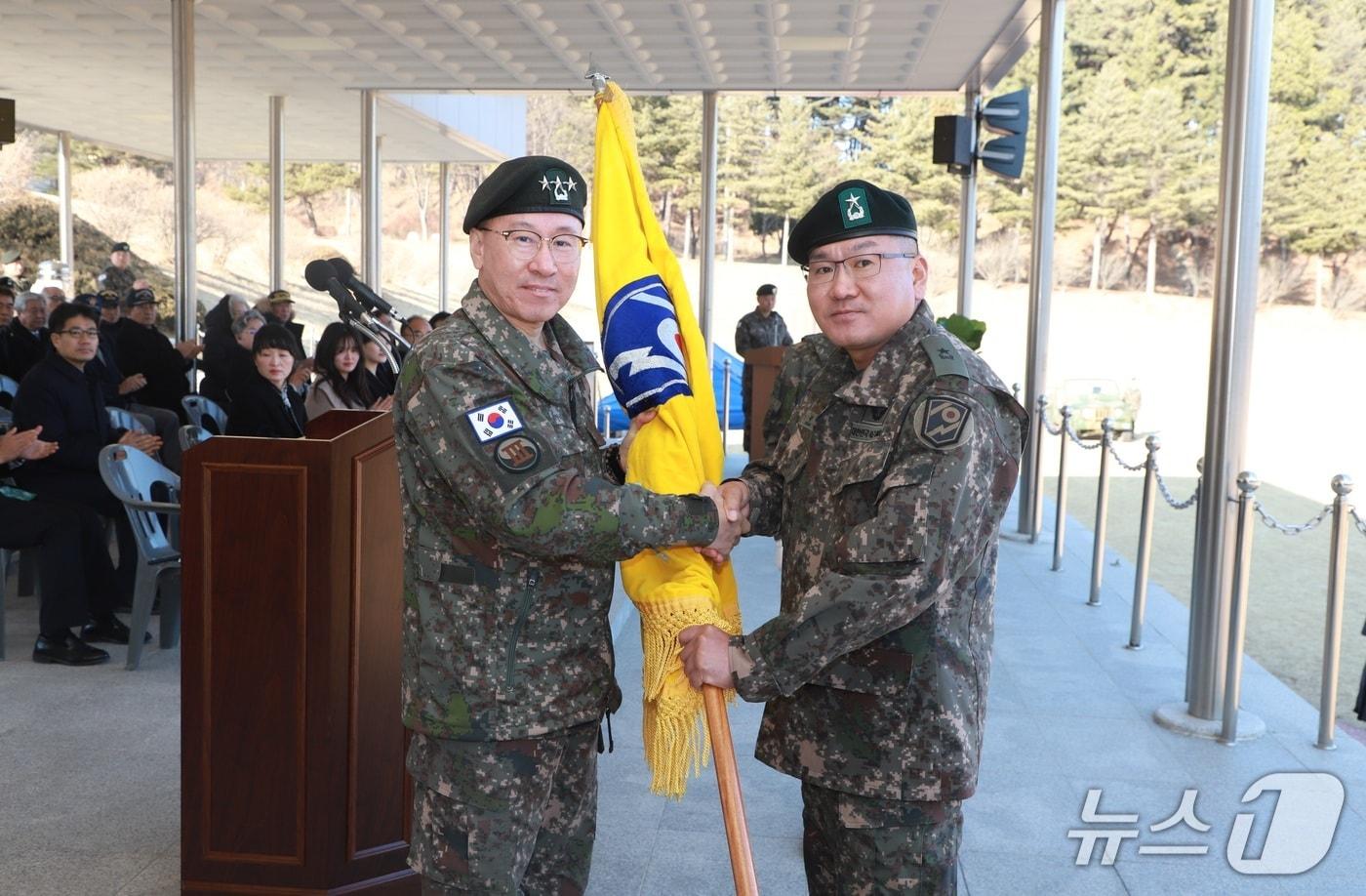 본문 이미지 - 2일 강원 양양군 소재 102기갑여단 사령부에서 열린 취임식에서 신재관 신임 여단장(오른쪽)이 이상렬 3군장으로부터 부대기를 이양받고 있다.(여단 측 제공, 재판매 및 DB 금지) 2026.2.2/뉴스1