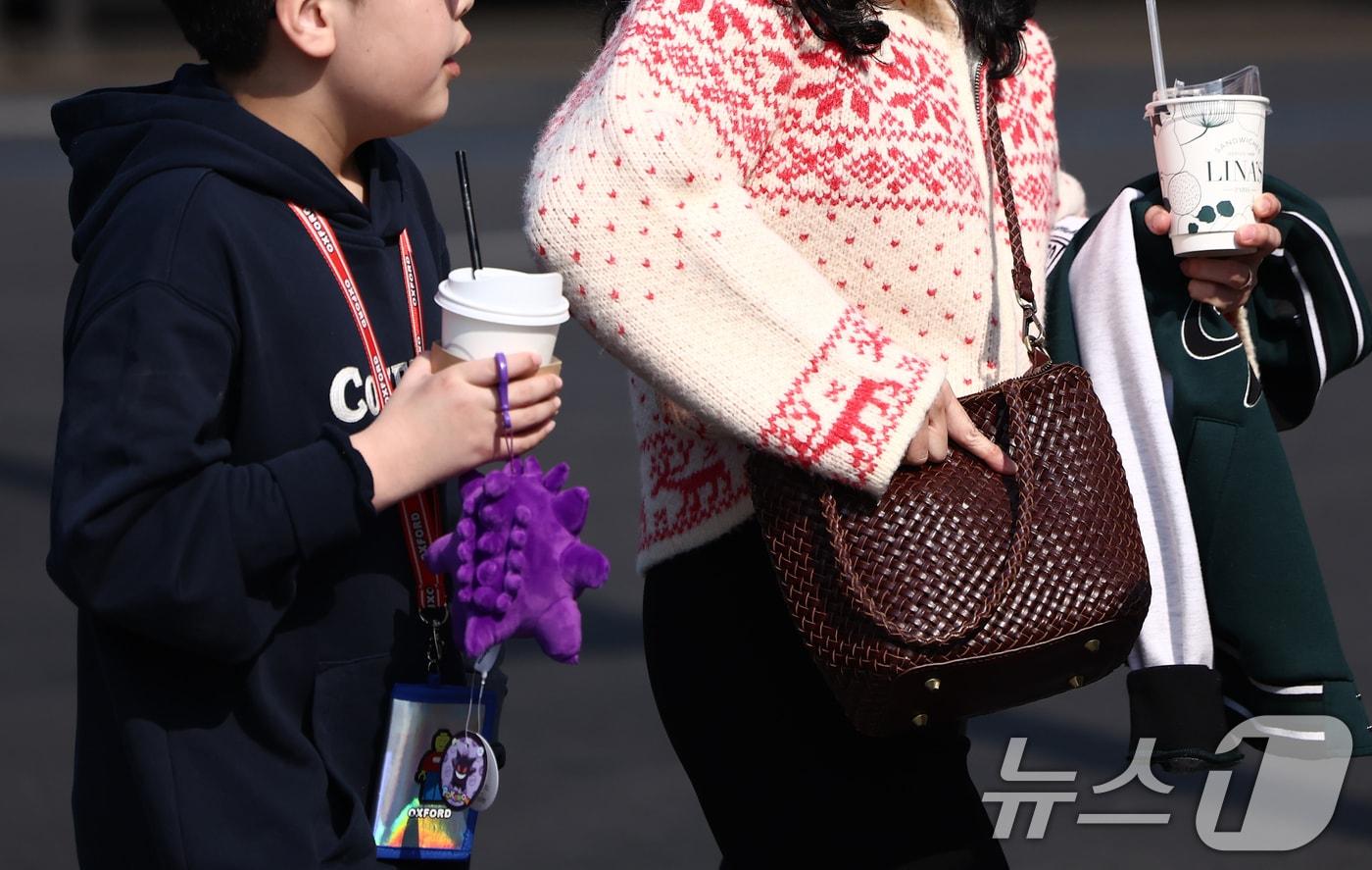 본문 이미지 - 서울 광화문 사거리에서 시민이 외투를 들고 발걸음을 옮기고 있다. 2026.2.20 ⓒ 뉴스1 김민지 기자