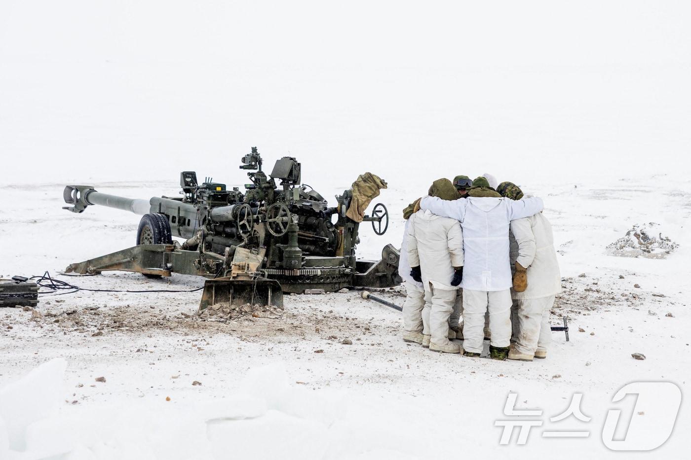 본문 이미지 - 19일(현지시간) 캐나다군의 북극 방어 훈련 '나눅-누날리부트 작전'에 참가한 캐나다군 장병들이 캐나다 누나부트준주 캠브리지 베이에서 M777 곡사포 운용 전 모여서 작전 회의를 하고 있다. 2026.02.19. ⓒ 로이터=뉴스1
