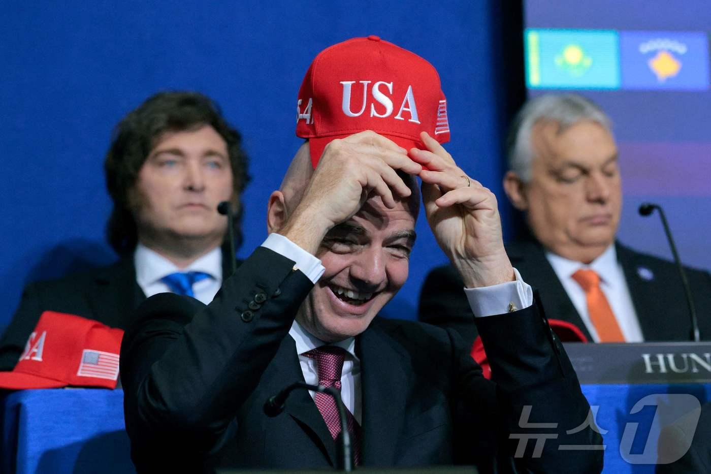 본문 이미지 - 19일(현지시간) 미국 워싱턴 D.C.에서 도널드 트럼프 미국 대통령이 주최한 '평화 위원회(Board of Peace)' 첫 이사회 회의에서 잔니 인판티노 국제축구연맹(FIFA) 회장이 USA가 새겨진 모자를 착용하는 모습이다. ⓒ AFP=뉴스1