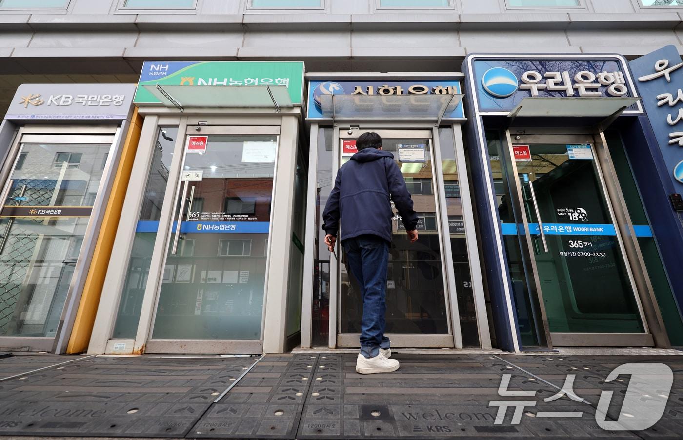 본문 이미지 - 22일 서울 시내 은행 ATM기 앞으로 시민들이 지나가고 있다. 2026.2.22 ⓒ 뉴스1 황기선 기자