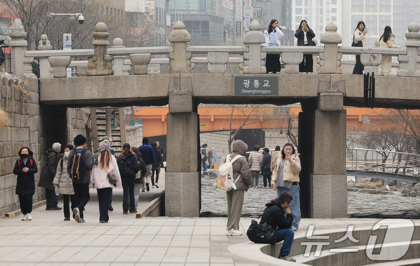 본문 이미지 - 서울 낮 최고 기온이 10도 이상 오르며 포근한 날씨를 보인 22일 오후 서울 청계천을 찾은 관광객들이 산책을 하고 있다. 2026.2.22 ⓒ 뉴스1 이호윤 기자