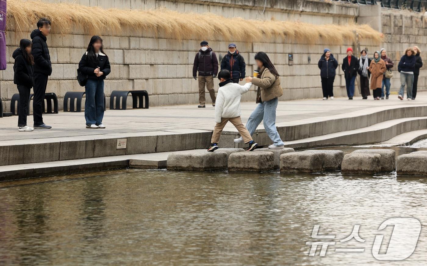 본문 이미지 - 서울 낮 최고 기온이 10도 이상 오르며 포근한 날씨를 보인 22일 오후 서울 청계천을 찾은 시민들이 산책을 하고 있다. 2026.2.22 ⓒ 뉴스1 이호윤 기자