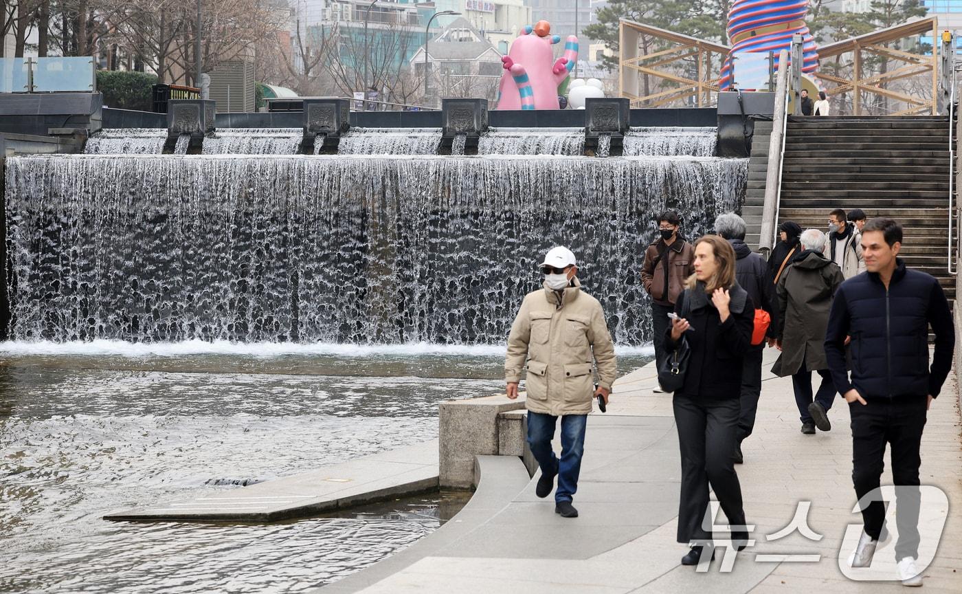 본문 이미지 - 서울 낮 최고 기온이 10도 이상 오르며 포근한 날씨를 보인 22일 오후 서울 청계천을 찾은 관광객들이 산책을 하고 있다. 2026.2.22 ⓒ 뉴스1 이호윤 기자