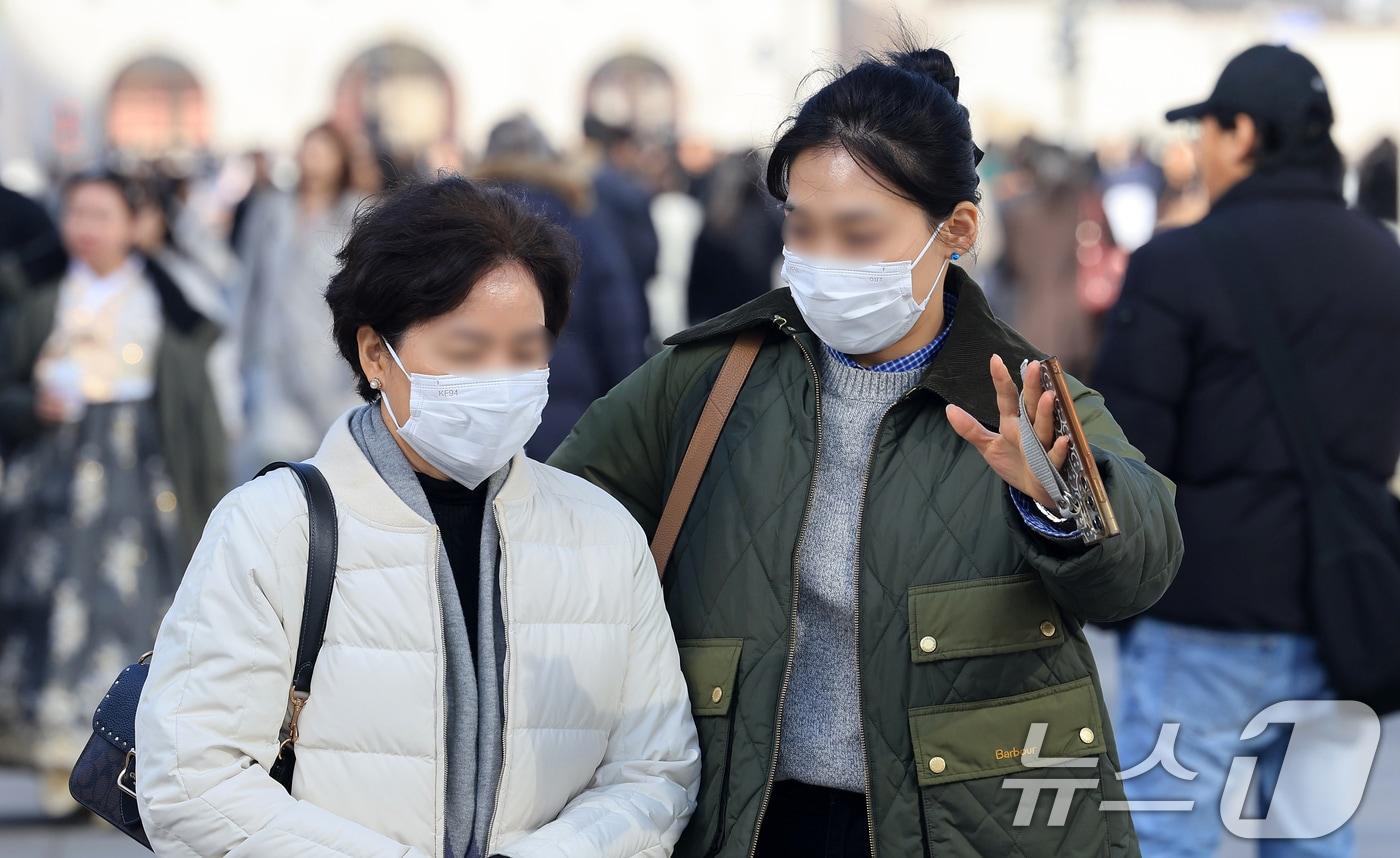 본문 이미지 - 서울과 경기 지역에 황사 유입으로 미세먼지 경보가 내려진 22일 서울 광화문광장에서 마스크를 쓴 시민들이 이동하고 있다. 2026.2.22 ⓒ 뉴스1 이호윤 기자