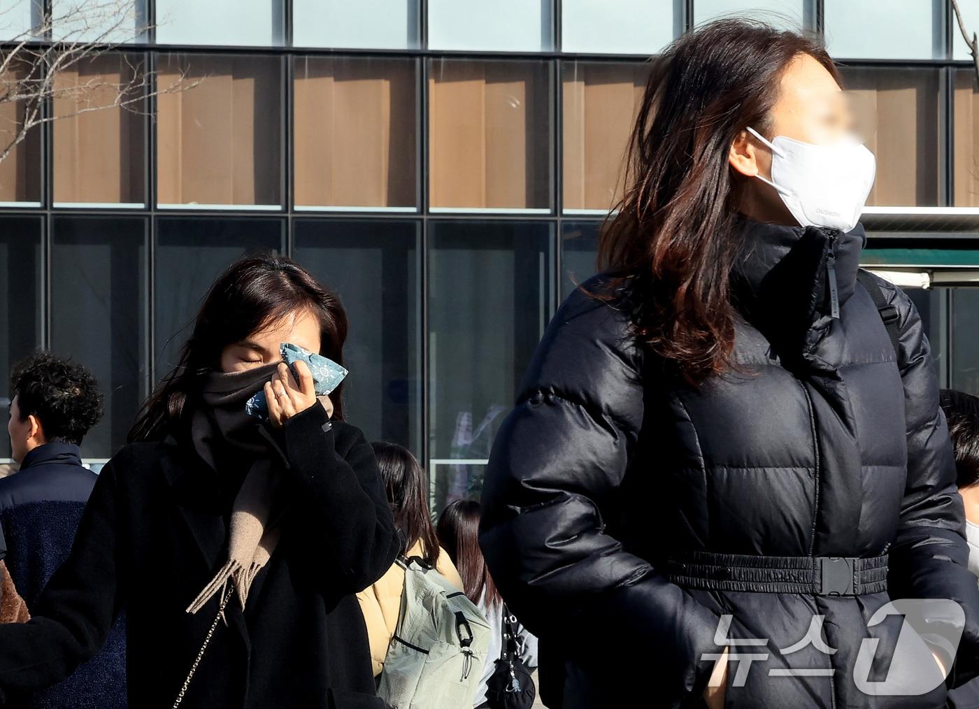 본문 이미지 - 서울과 경기 지역에 황사 유입으로 미세먼지 경보가 내려진 22일 서울 광화문광장에서 마스크를 쓴 시민들이 이동하고 있다. 2026.2.22 ⓒ 뉴스1 이호윤 기자