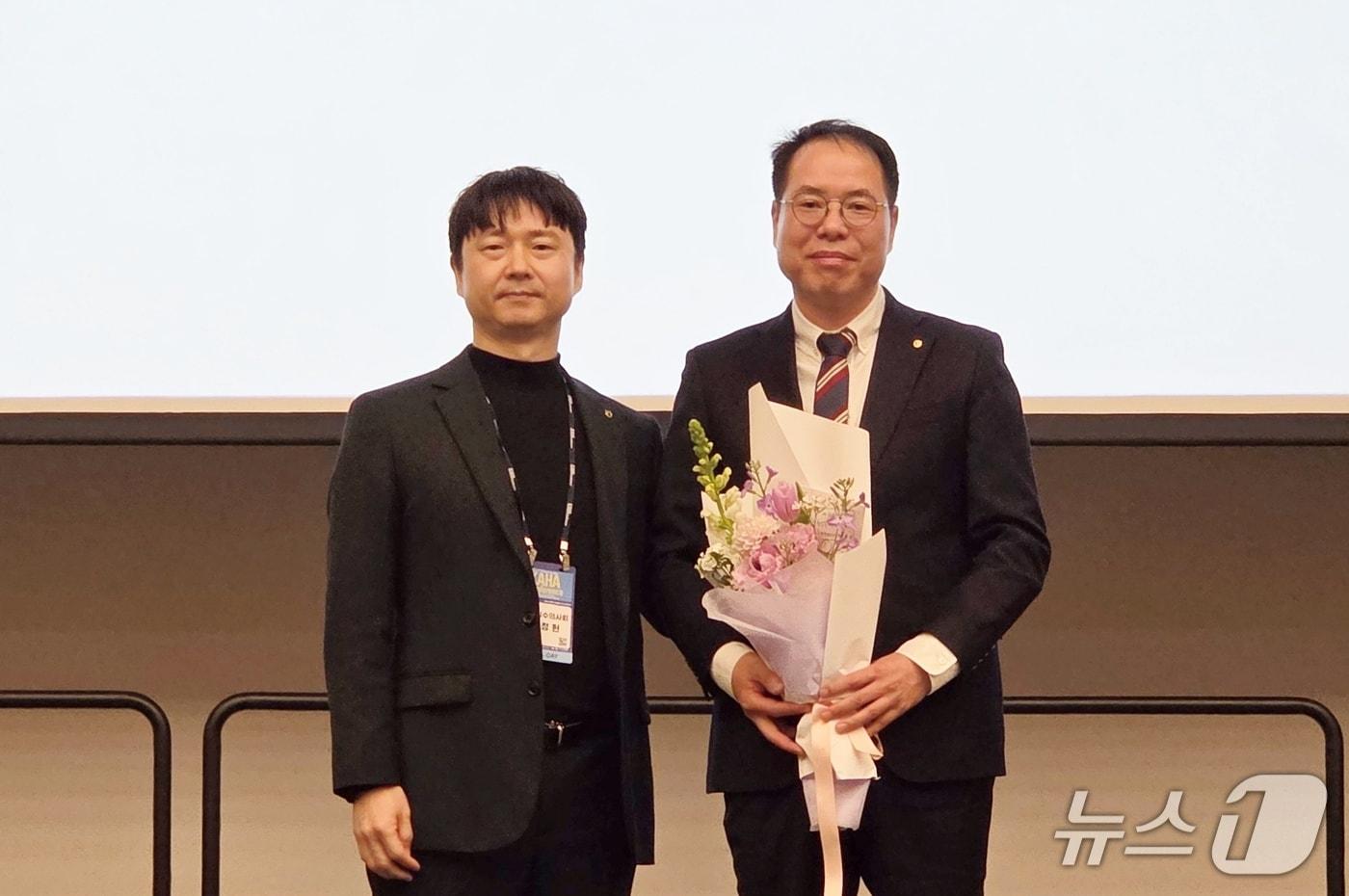 본문 이미지 - 박정현 인천시수의사회 회장(왼쪽)이 22일 송도컨벤시아에서 열린 이취임식에서 오보현 제16대 회장에게 꽃다발을 전달하고 있다(수의사회 제공). ⓒ 뉴스1