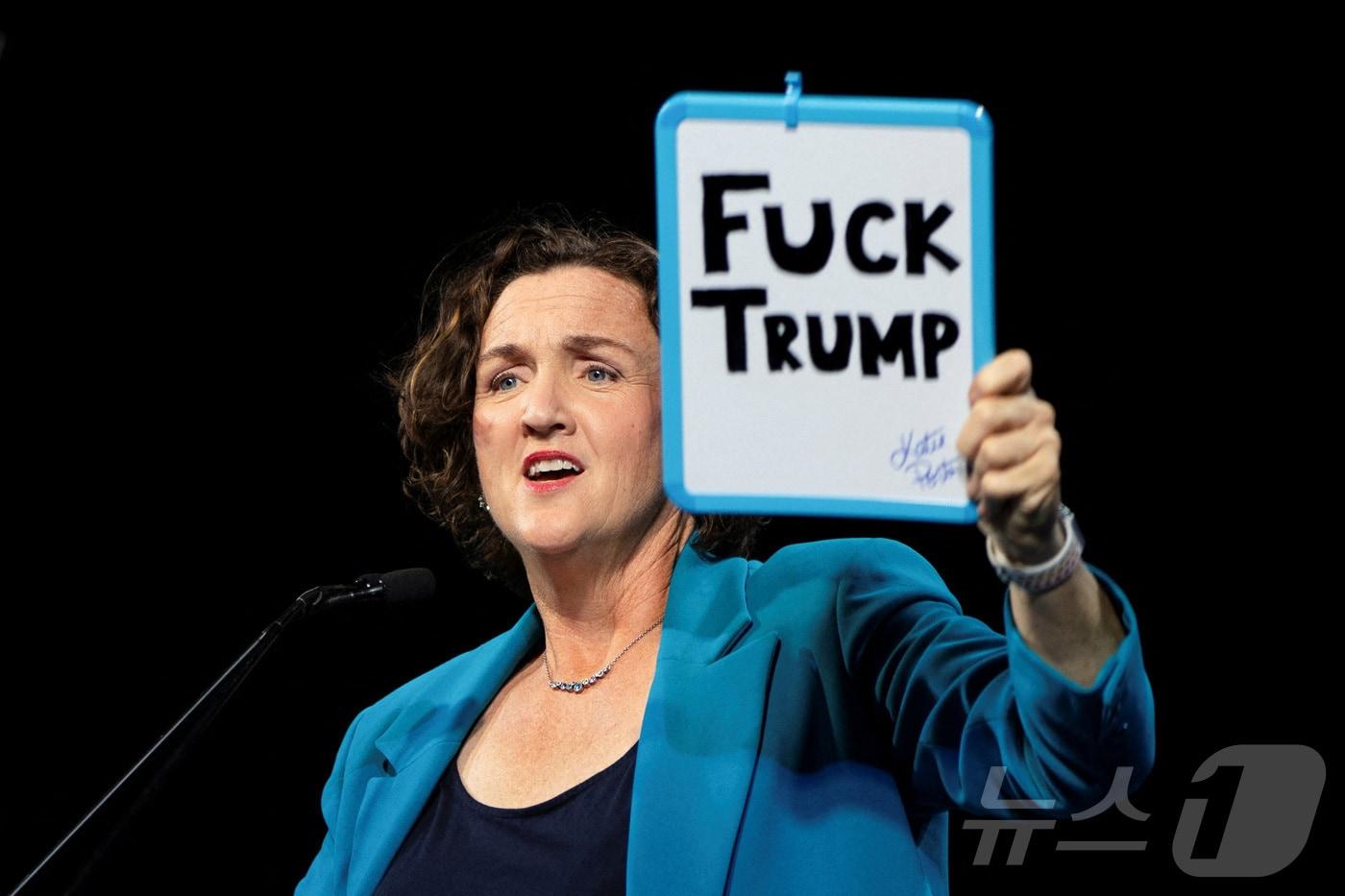 본문 이미지 - 2월 21일(현지시간) 캘리포니아 주지사 후보 케이티 포터가 미국 캘리포니아주 샌프란시스코에서 열린 캘리포니아 민주당 전당대회에서 도널드 트럼프 대통령을 비판하는 문구가 적힌 팻말을 들어 보이고 있다. 2026. 02. 21. ⓒ 로이터=뉴스1