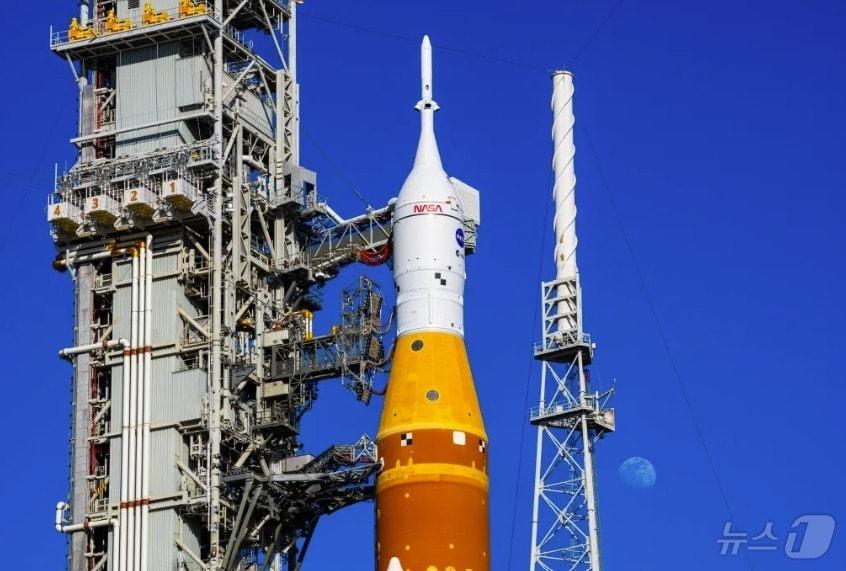 본문 이미지 - 지난 1월 29일, 플로리다주 케네디 우주센터에서 이동식 발사대에 실린 우주 발사 시스템(SLS) 로켓과 오리온 우주선 뒤로 달이 보이고 있다. 2026.01.29(NASA 제공) ⓒ 뉴스1 김민수 기자