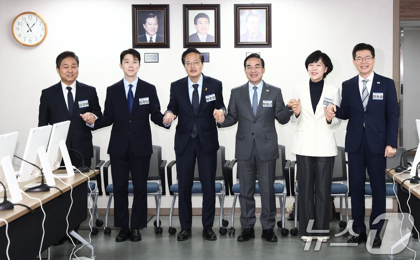 본문 이미지 - 지난 23일 오전 서울 영등포구 더불어민주당 당사에서 열린 중앙당공천광리위원회 2차 회의 및 광역단체장 후보자 면접에서 서울시장 후보들이 손을 맞잡고 기념촬영을 하고 있다. 왼쪽부터 김영배 의원, 김형남 전 군인권센터 사무국장, 박주민·박홍근·전현희 의원, 정원오 성동구청장. 2026.2.23 ⓒ 뉴스1 김민지 기자