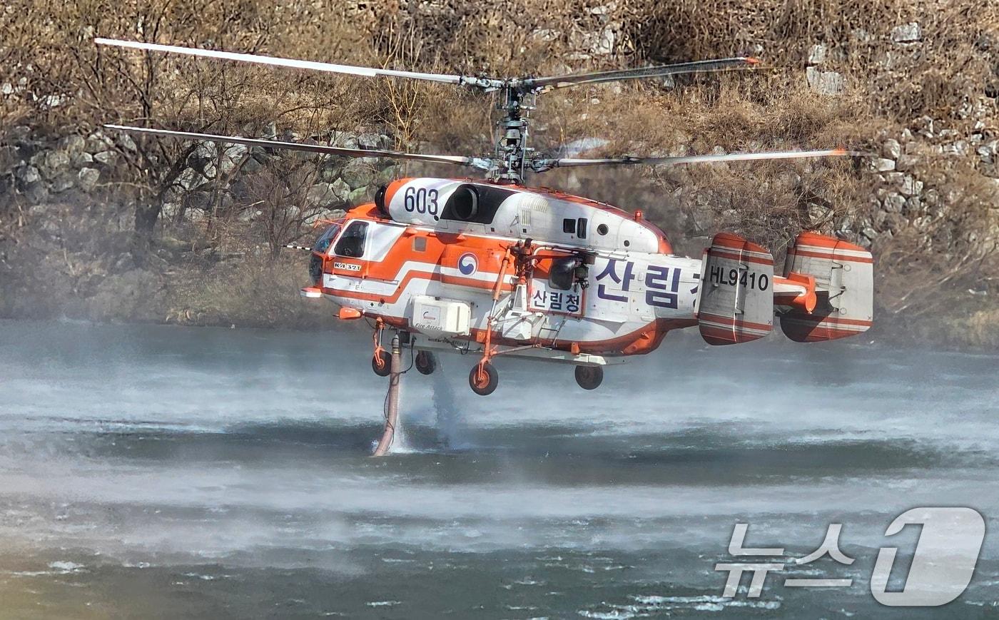 본문 이미지 - 경남 함양 산불 사흘째인 23일 오전 함양군 휴천면 임천에서 산림청 헬기가 물을 담수하고 있다. 2026.2.23 ⓒ 뉴스1 한송학 기자