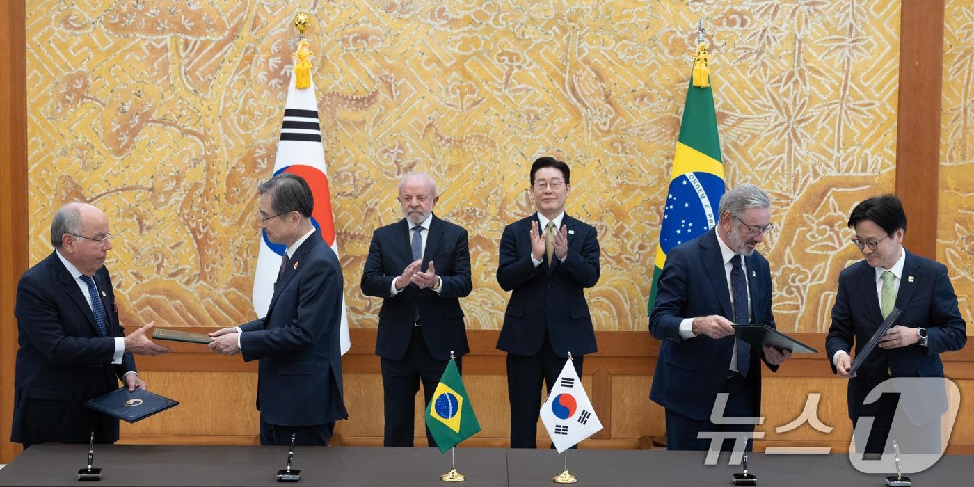 본문 이미지 - 조현 외교부 장관과 김정관 산업통상부 장관, 마우루 비에이라 브라질 외교부 장관, 마르시우 엘리아스 호쟈 개발산업상공서비스부 차관이 23일 청와대에서 이재명 대통령과 브라질 루이스 이나시우 룰라 다 시우바 대통령이 임석한 가운데 통상·생산 통합 협약을 체결한 뒤 악수하고 있다. 2026.2.23 ⓒ 뉴스1 이재명 기자