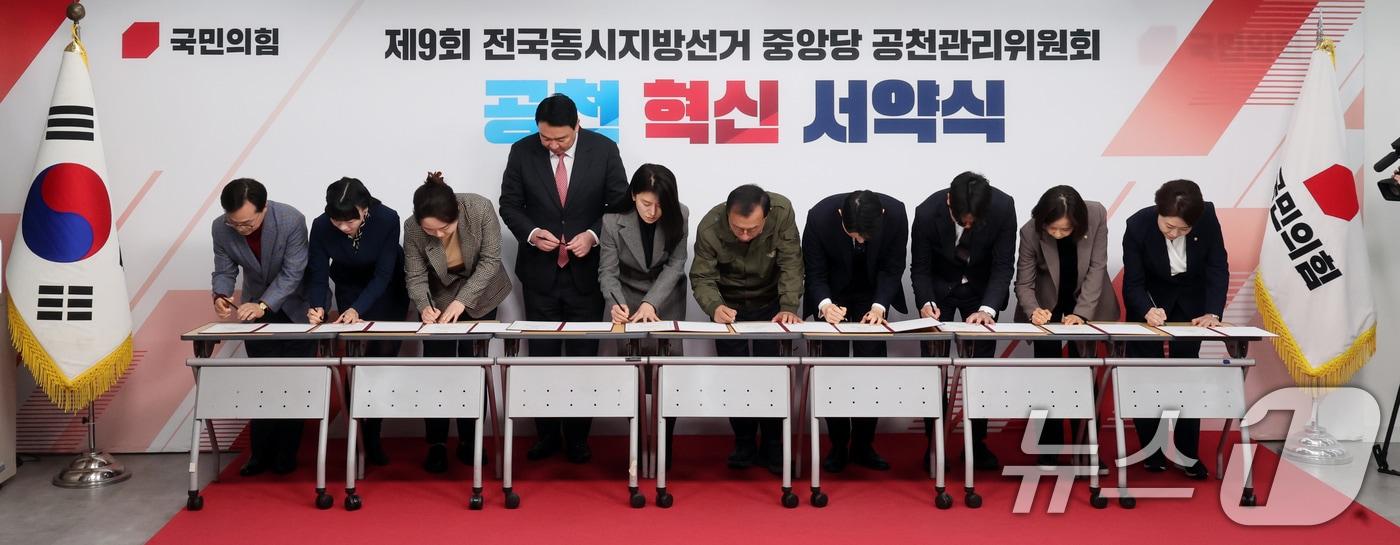 본문 이미지 - 이정현 공천관리위원장과 위원들이 23일 오후 서울 영등포구 여의도 국민의힘 중앙당사에서 열린 '제9회 전국동시지방선거 중앙당 공천관리위원회 공천 혁신 서약식'에서 서약서에 서명을 하고 있다. 2026.2.23 ⓒ 뉴스1 황기선 기자
