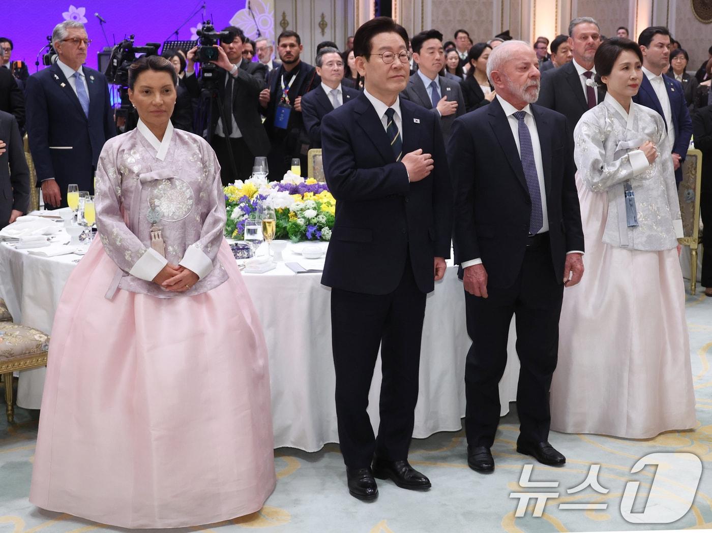 본문 이미지 - 이재명 대통령이 23일 청와대에서 열린 루이스 이나시우 룰라 다시우바 브라질 대통령 국빈 방한 환영 만찬에서 국민의례를 하고 있다. 왼쪽부터 루이스 이나시우 룰라 다시우바 브라질 대통령 부인 호잔젤라 다시우바 여사, 이 대통령, 룰라 대통령, 김혜경 여사. (청와대통신사진기자단) 2026.2.23 ⓒ 뉴스1 이재명 기자