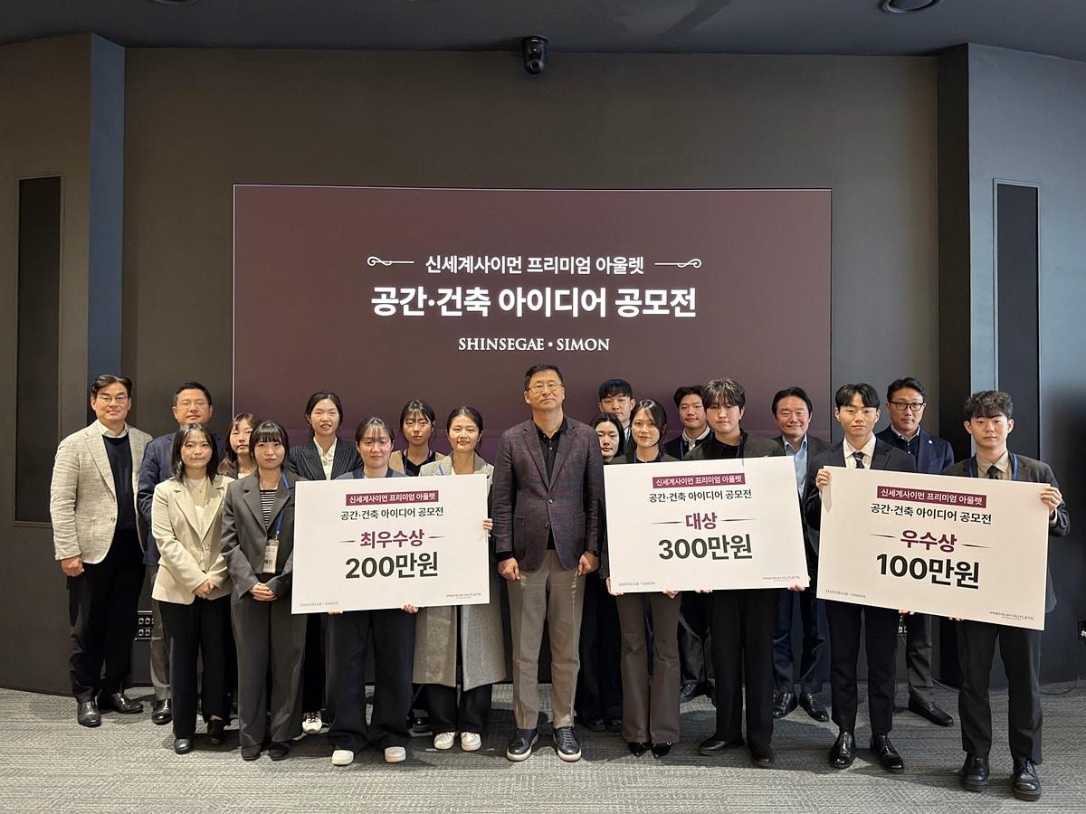 본문 이미지 - 23일 신세계남산에서 진행된 신세계사이먼  ‘공간·건축 아이디어 공모전’ 본선에 진출한 참가 팀들과 신세계사이먼 임원(가운데 김영섭 대표이사)들이 기념 사진을 촬영 중이다. (신세계사이먼 제공)