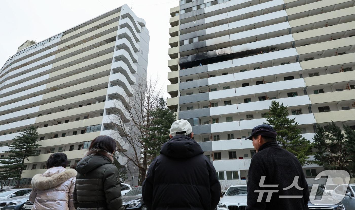 본문 이미지 - (사진은 기사 내용과 무관함) 24일 오전 서울 강남구 은마아파트에서 주민들이 화재 현장 합동감식을 보고 있다. 2026.2.24 ⓒ 뉴스1 안은나 기자
