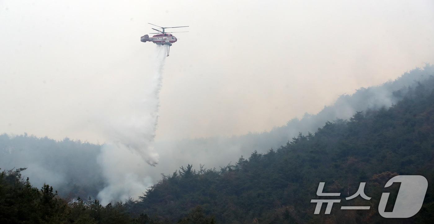 본문 이미지 - 경남 밀양 산불 이틀째인 24일 오전 삼랑진읍 검세리 산불 현장에서 산불진화 헬기가 진화 작업을 벌이고 있다. 2026.2.24 ⓒ 뉴스1 윤일지 기자