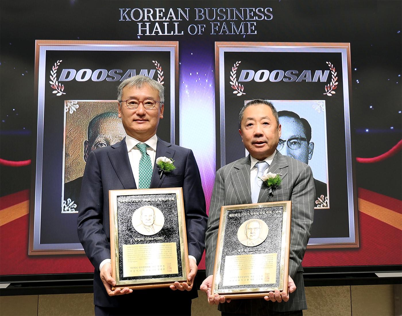 본문 이미지 - 24일 서울 이화여대 경영대학 60주년 기념홀에서 열린 ‘대한민국 기업가 명예의 전당’ 헌액식에서 박정원 두산그룹 회장(오른쪽)이 헌액 기념패를 들고 양희동 한국경영학회 회장(왼쪽)과 함께 기념촬영을 하고 있다.(두산 제공)