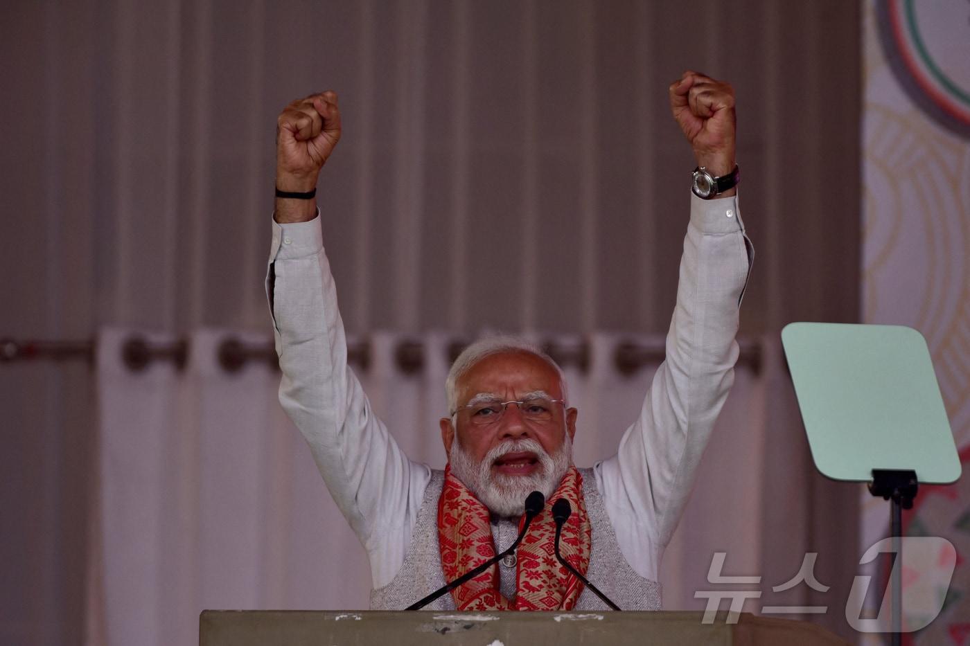 본문 이미지 - 나렌드라 모디 인도 총리가 14일 구와하티에서 연설을 하며 두 손을 번쩍 들어 보이고 있다. 2026.2.14 ⓒ 로이터=뉴스1
