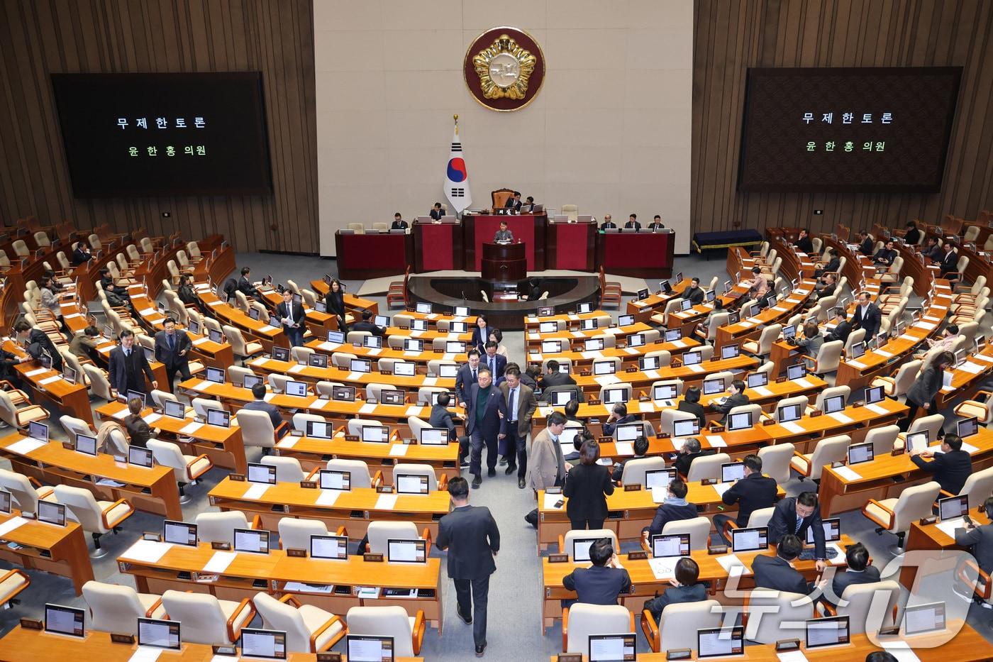 본문 이미지 - 윤한홍 국민의힘 의원이 24일 서울 여의도 국회에서 열린 제432회국회(임시회) 제8차 본회의에서 상법 일부개정법률안(대안)에 대한 무제한 토론(필리버스터)에 돌입하자 더불어민주당 의원들이 퇴장하고 있다. 2026.2.24 ⓒ 뉴스1 신웅수 기자