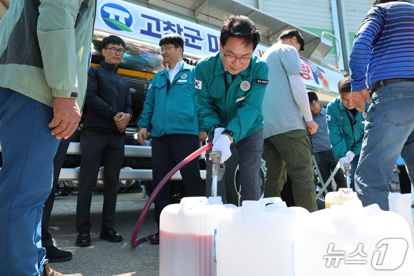 본문 이미지 - 심덕섭 고창군수가 유용미생물을 옮겨담고 있다.(고창군 제공. 재판매 및 DB금지)