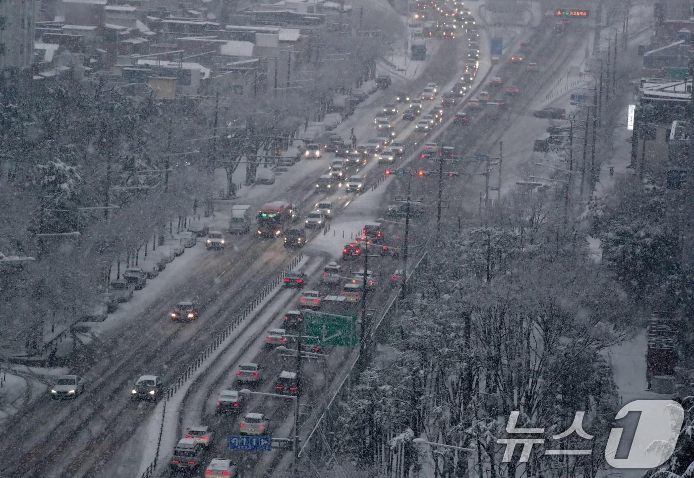 본문 이미지 - 24일 오후 대구 수성구 범안로 앞산터널 방면 차량이 함박눈에 갇혀 정체를 빚고 있다. 2026.2.24 ⓒ 뉴스1 공정식 기자