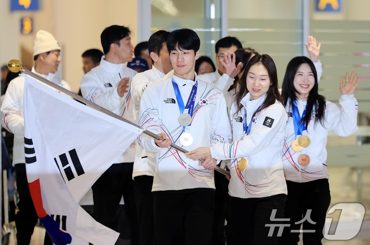 본문 이미지 - 쇼트트랙 최민정, 황대헌, 김길리 등 대한민국 국가대표팀이 2026 밀라노·코르티나담페초 동계올림픽을 마치고 24일 인천국제공항을 통해 귀국해 태극기를 흔들고 있다. 대한민국은2026 밀라노·코르티나담페초 동계올림픽에서 총 10개의 메달(금 3, 은 4, 동 3)과 종합순위 13위를 기록했다 2026.2.24 ⓒ 뉴스1 이호윤 기자