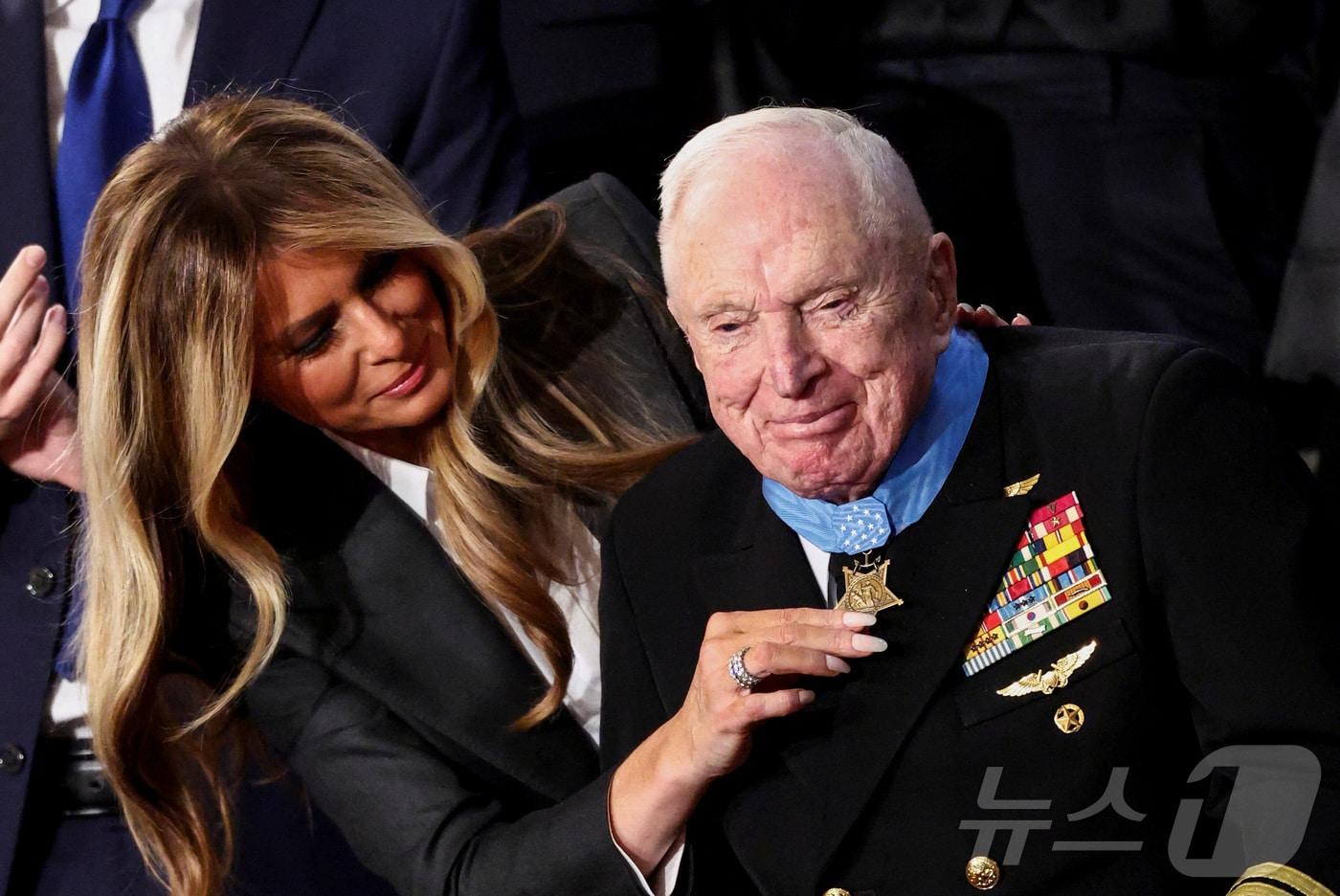 본문 이미지 - 24일(현지시간) 워싱턴 DC 미국 국회의사당 하원 회의장에서 열린 도널드 트럼프 미국 대통령의 2기 첫 국정연설 중 영부인 멜라니아 여사가 한국전쟁 참전용사 로이스 윌리엄스(100세)에게 명예훈장을 수여하고 있다. 2026.02.24. ⓒ 로이터=뉴스1